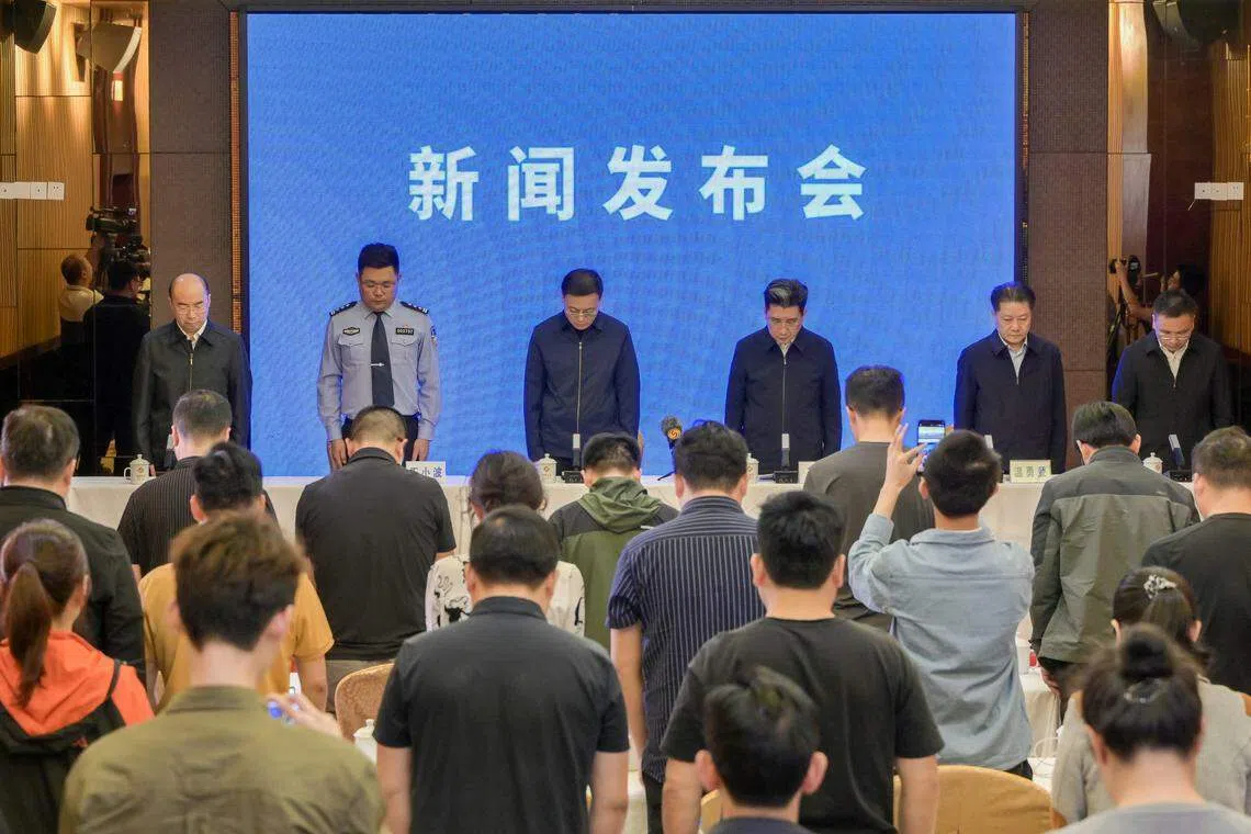 中共梅州市委书记马正勇（左三）、梅州市长王晖（右三）星期四（5月2日）在新闻发布会上率领与会官员全体起立为高速公路塌陷事故遇难人员默哀1分钟。（中新社）