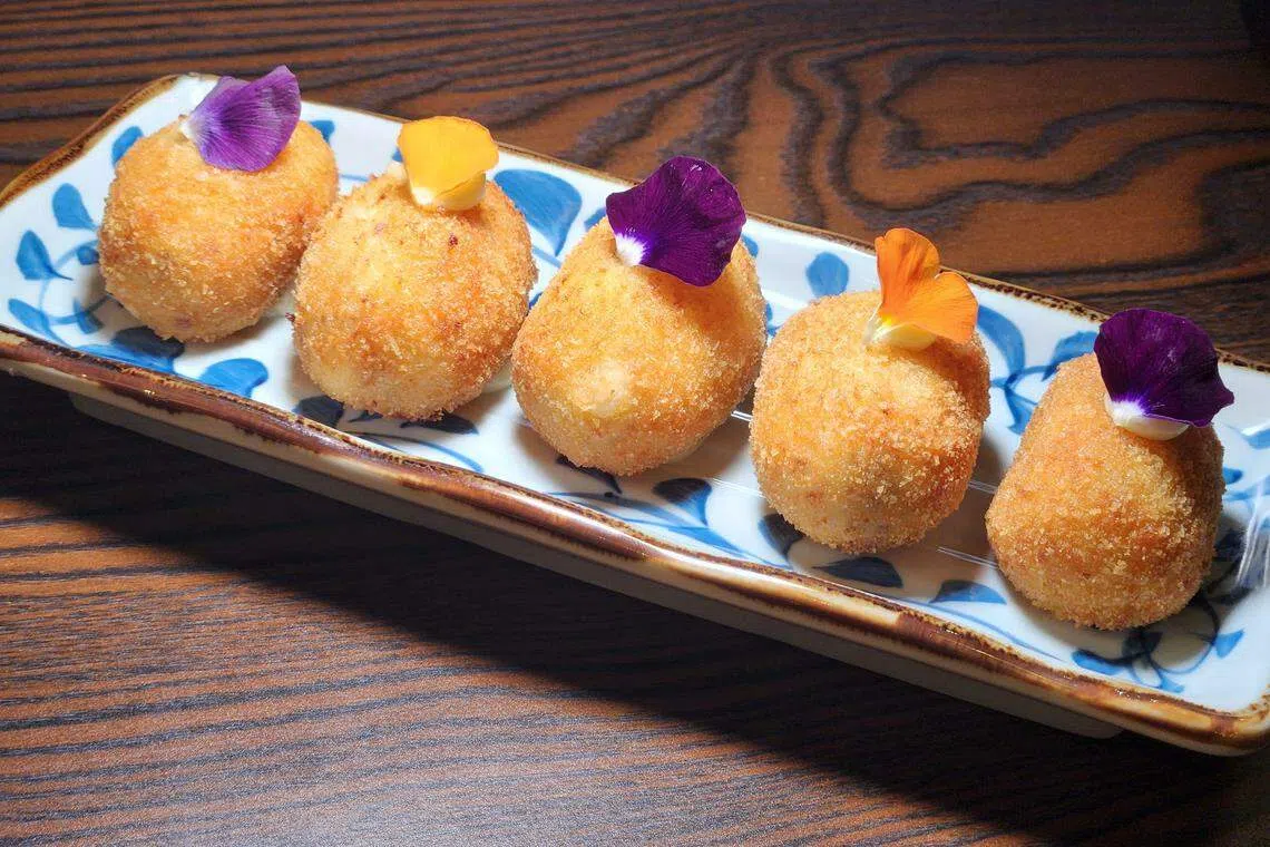 Bolonia Singapore炸得外脆内软的白酱拌伊比利亚猪肉火腿球。（陈爱薇摄）