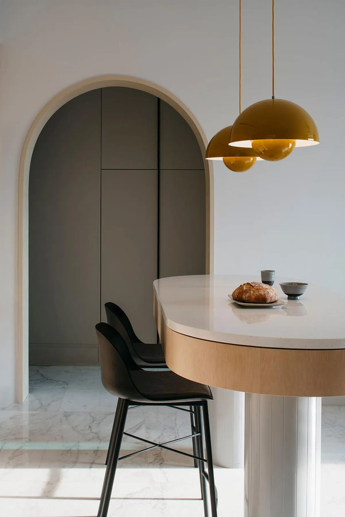 挂在吧台上一对两个半圆叠成的Louis Poulsen淡黄吊灯，呼应周围的木色。