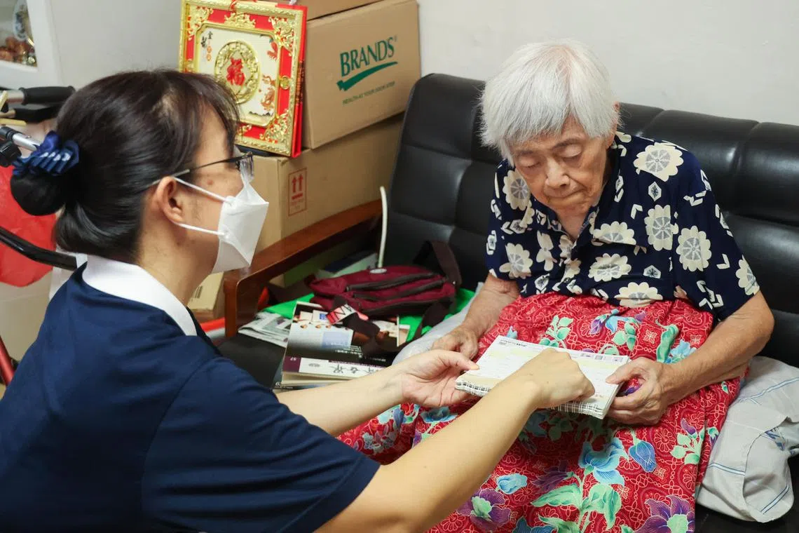 慈济义工陈秀菁（左）上门探访王克芳时，会提醒她什么时候去看医生。（邝启聪摄）