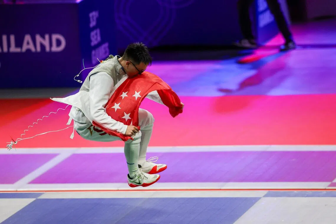 陈元康跳起庆祝，作出亲吻国旗的样子。（白艳琳摄）