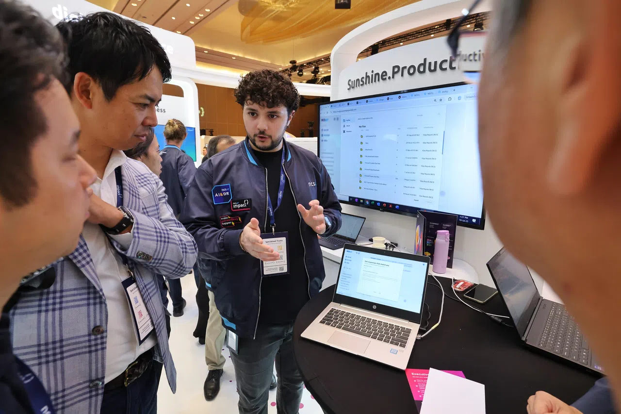 恩士迅影响力论坛会场内，恩士迅工作人员正在为参会者介绍新宣布的Sunshine Productivity人工智能工具。（唐家鸿摄）