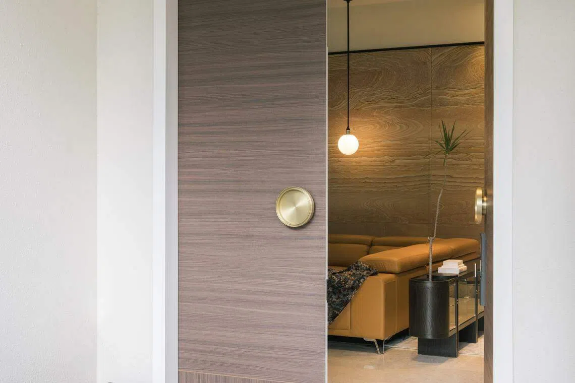 砂岩墙前一盏圆形吊灯散发的柔光，有如日出洒入居室之中。（Metre Architects）