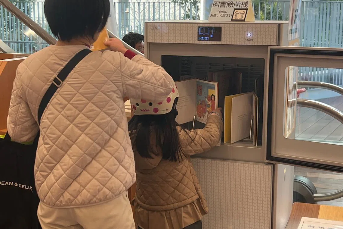 图书馆内配备书本消毒机。（叶孝忠摄）