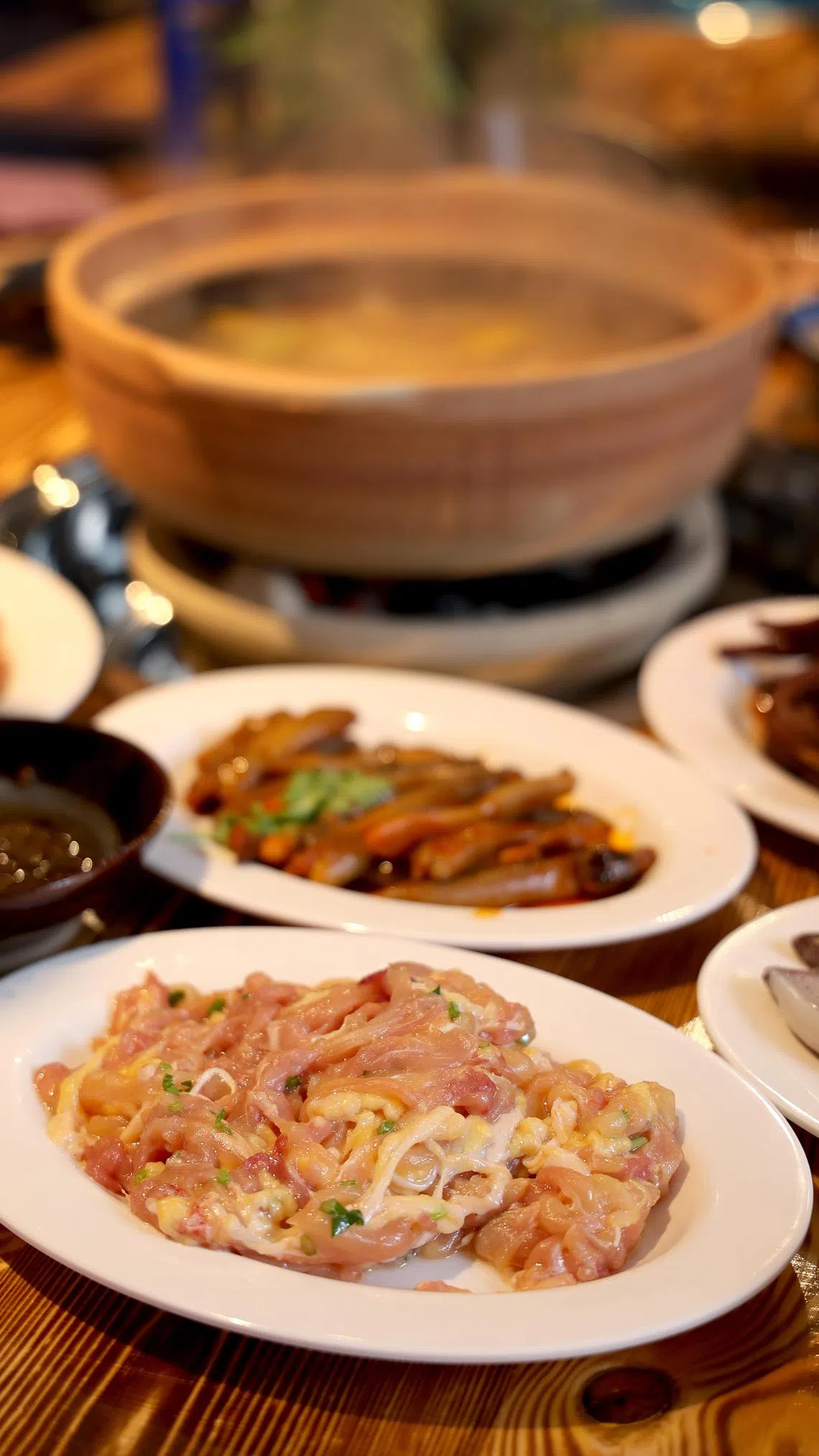 鸡腿去骨后切成细条，放入火锅快速涮煮8至10秒即捞起。（龙国雄摄）