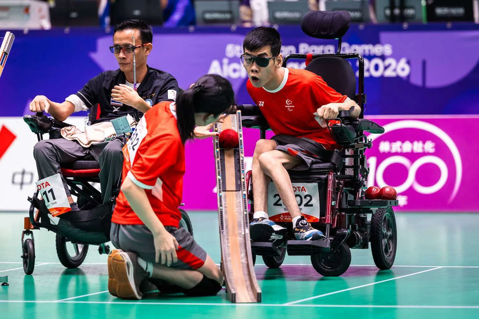 我国19岁小将颜恺宏（右一）与体育助手合作，为我国在残亚运会硬地滚球BC3级项目收获一枚银牌。（新加坡全国残奥理事会提供）