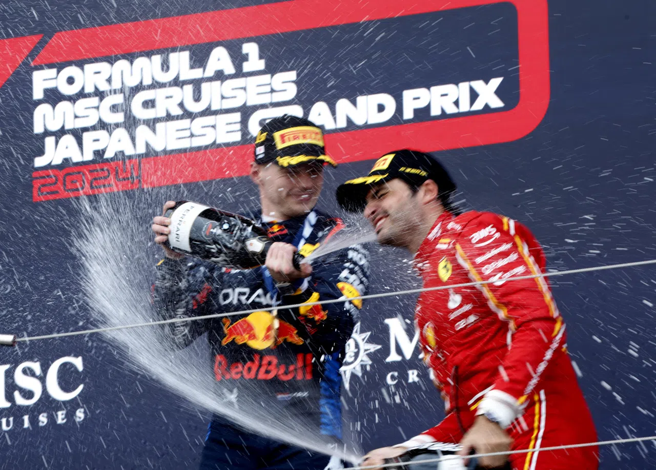 日本大奖赛冠军费斯塔彭（左）和获得季军的塞恩斯一起庆祝胜利。（路透社）