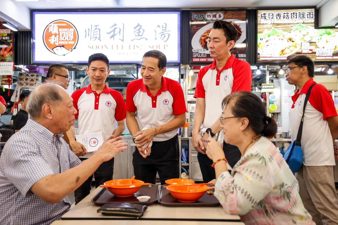 谢镜丰（左三）、邱永豪（右三）和李健铨（左二）星期六到大巴窑走动。他们在上届大选代表人民党出征碧山—大巴窑集选区，来届很可能继续在这个集选区参选。（叶振忠摄）