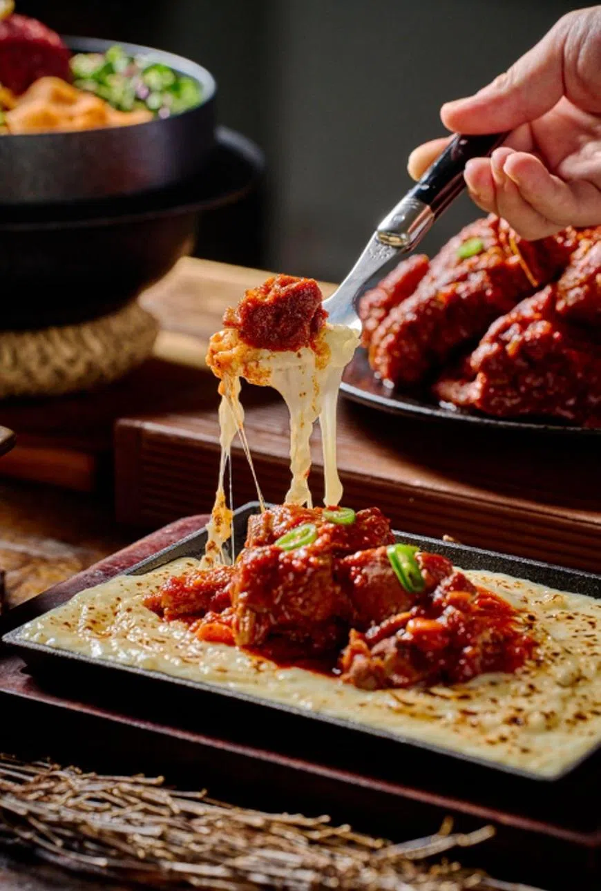 辣猪肩肉三重芝士烩饭选用美国猪肩肉，以秘制辣酱、韩式辣椒粉与香料慢炖，搭配烩饭享用。（餐馆提供）