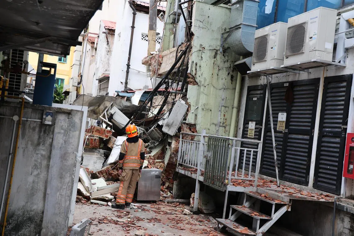 两店屋后方坍塌严重，墙体、电线和钢筋堆积在后巷。（陈斌勤摄）