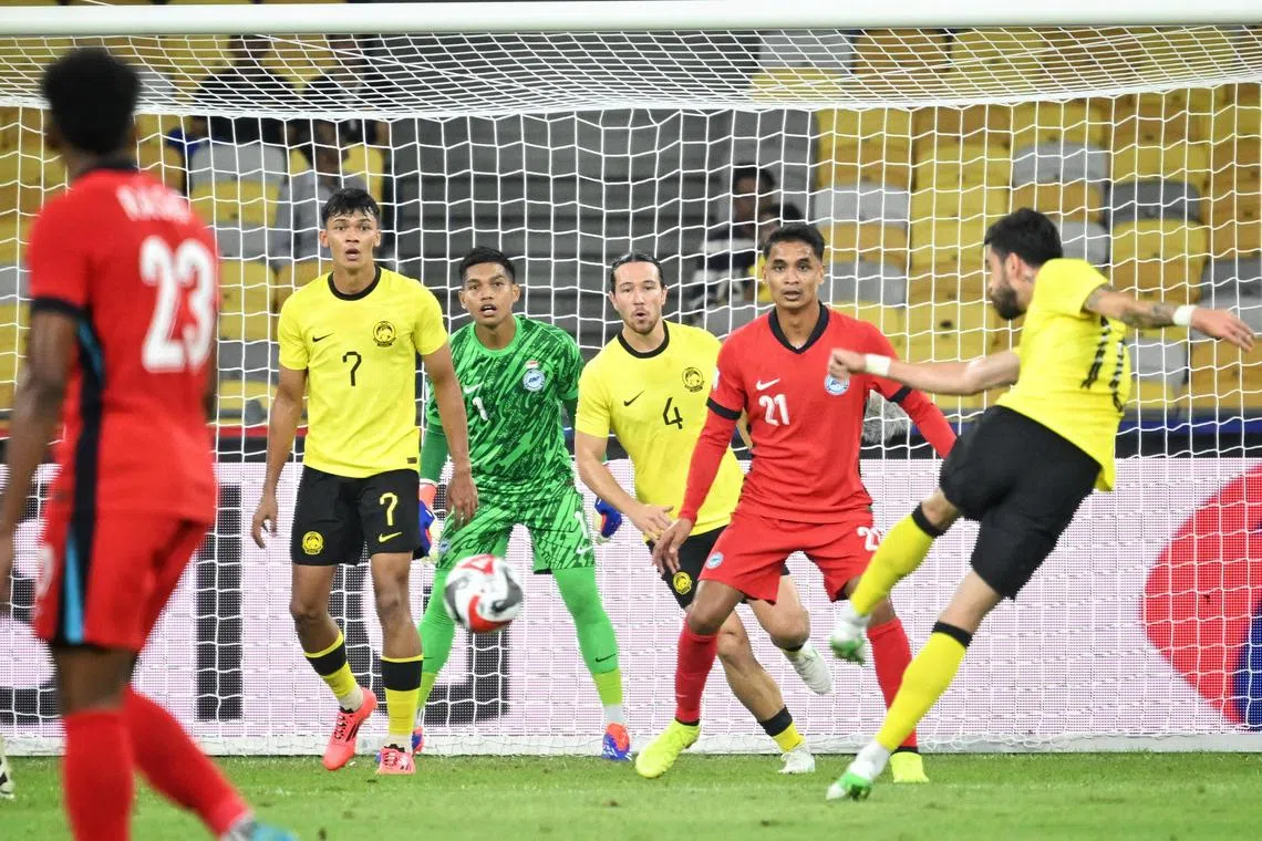 马来西亚（黄衣）不断发起攻势，但始终难以敲开我国龙门。（海峡时报）