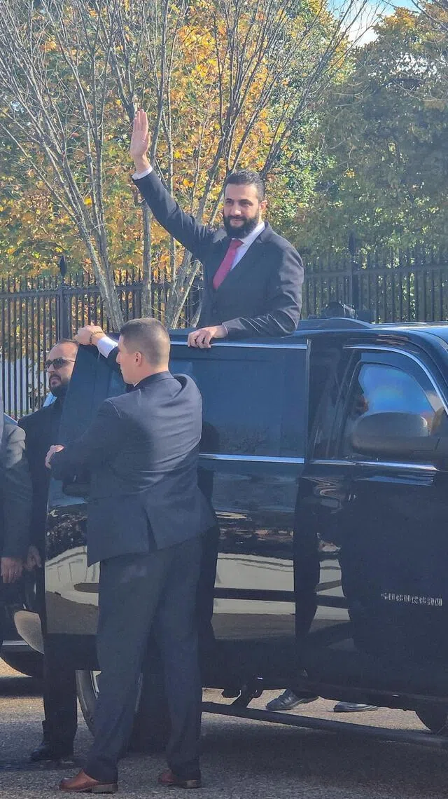 叙利亚总统沙拉在华盛顿与美国总统特朗普会晤后，在白宫外的街道上向支持者挥手致意。（路透社）