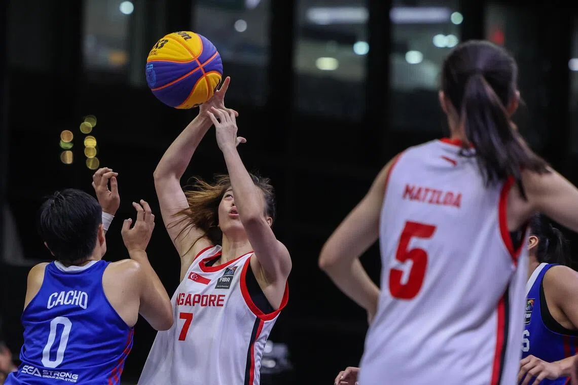 菲律宾球员（蓝衣）对新加坡队员（白衣）施加了非常大的防守压力，让后者几乎没有出手空间。（白艳琳摄）