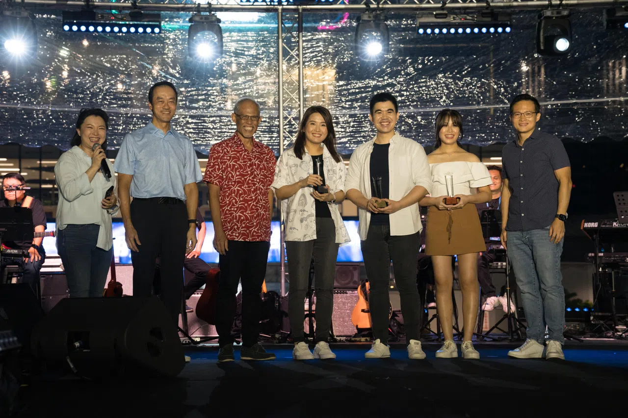 人力部兼永续发展与环境部高级政务部长许宝琨医生（左二起）、社会及家庭发展部长兼卫生部第二部长马善高、以及东北区市长朱倍庆（右一）颁奖给“新谣新声代”歌唱比赛的三名优胜者（右二起）。左一为主持人蔡礼莲。（弹唱人提供）