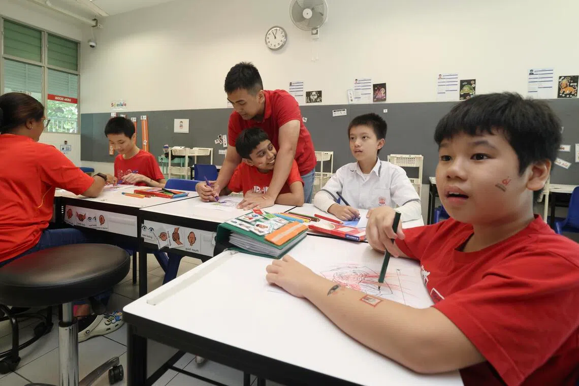 慈明学校在国庆期间举办活动，让学生为沙爹、鸡饭和榴梿等本地特色美食的图案上色。（郑一鸣摄）