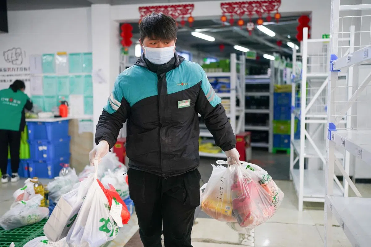 4月1日早上，叮咚买菜位于上海松江区的蔬果大仓和闵行区的前置仓里，配送员将货品装运上车。（新华社）
