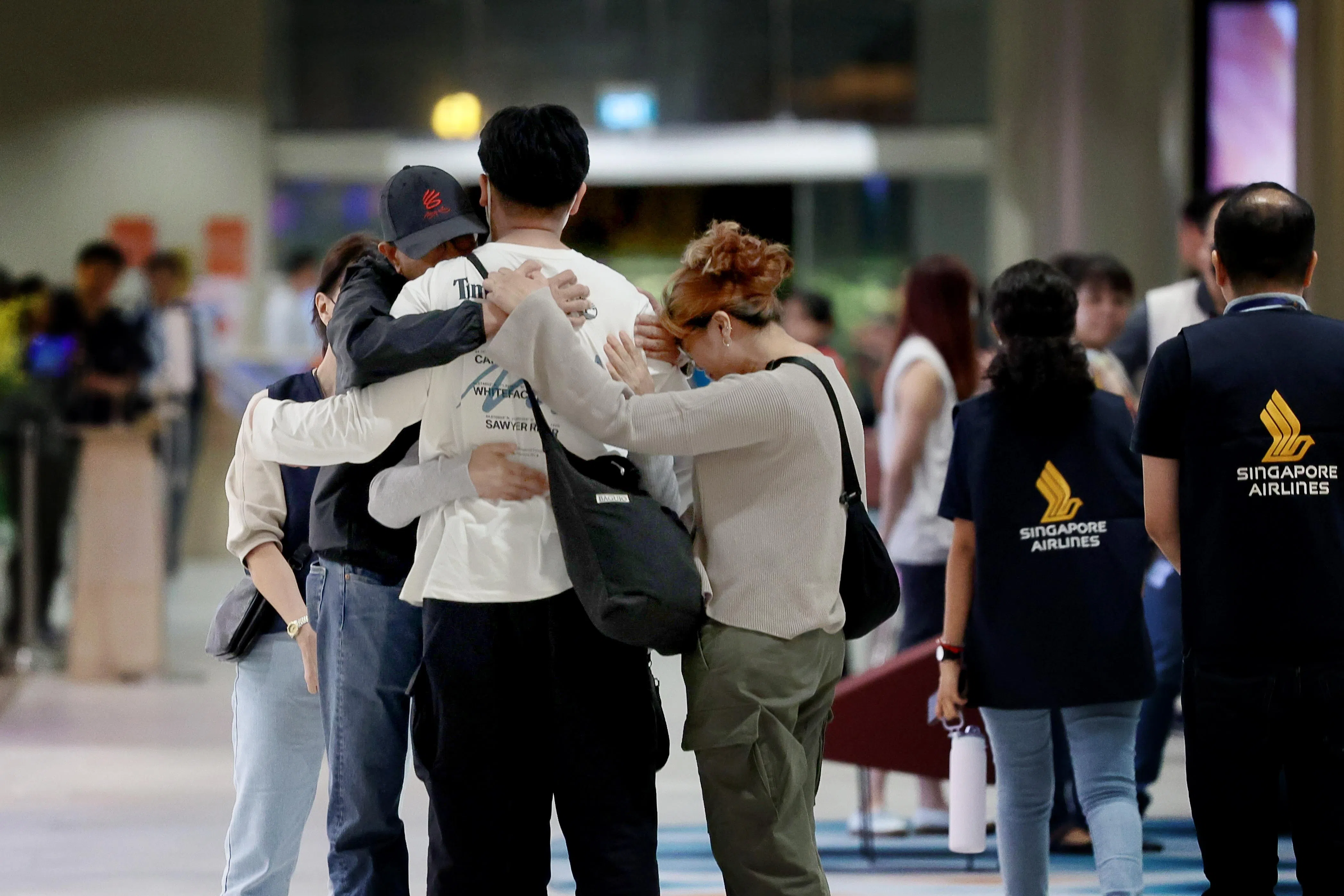 新航SQ321事故中，第一批乘客和机组人员安全返回新加坡时，家人看到他们安全落地，不禁相拥，如释重负。（陈渊庄摄）