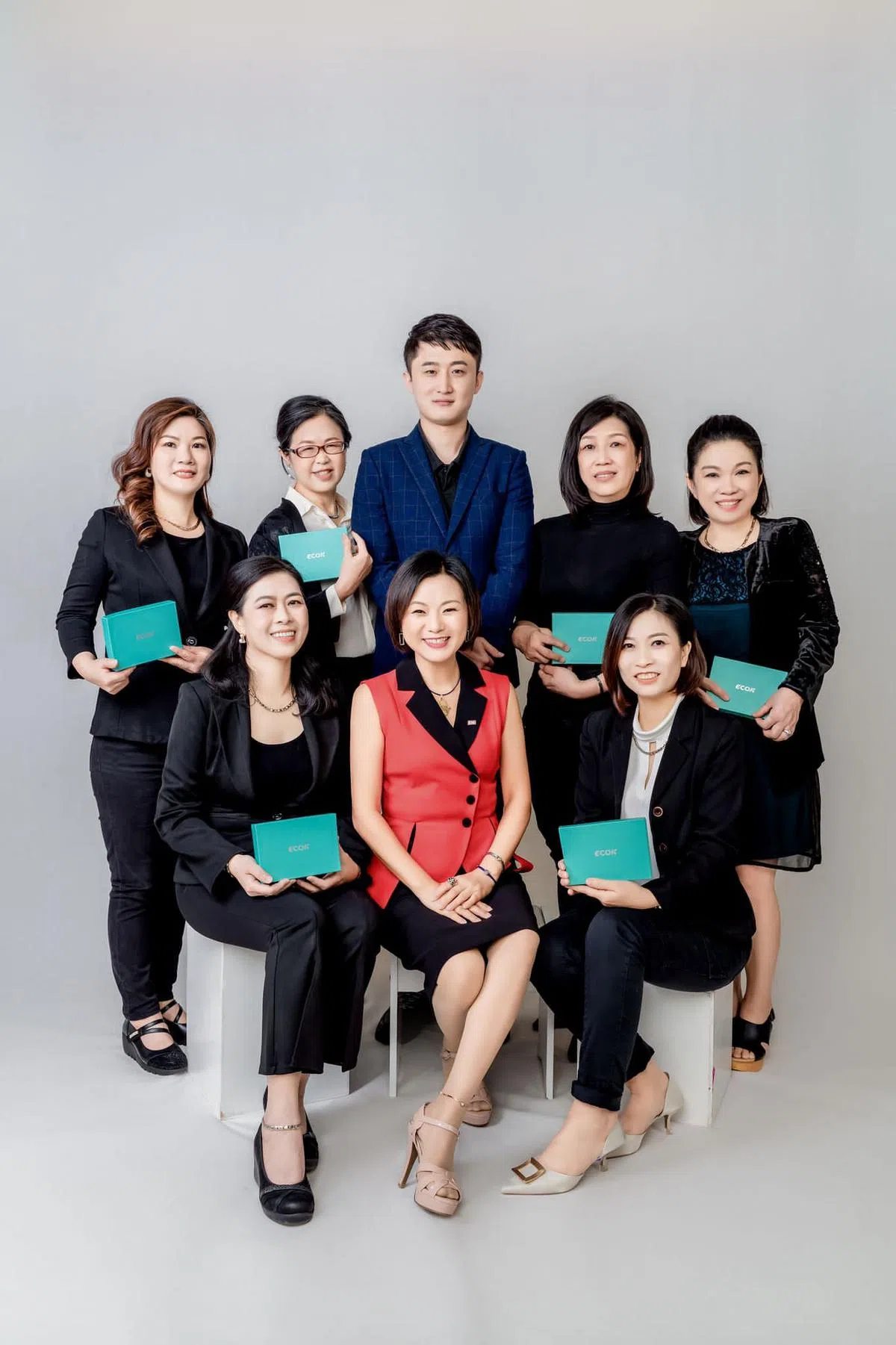 何灿红（前排中）亲自带领员工们一起打拼，共同学习成长，分享养生保健知识和方法，让更多人受益。（受访者提供）