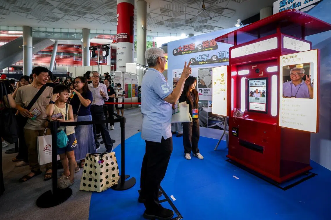 “报纸头条拍照区”可让公众拍下照片后即时生成《联合早报》或《新明日报》的“头版新闻”，看自己成为“新闻人物”，趣味十足，是其中一个打卡热点。（叶振忠摄）