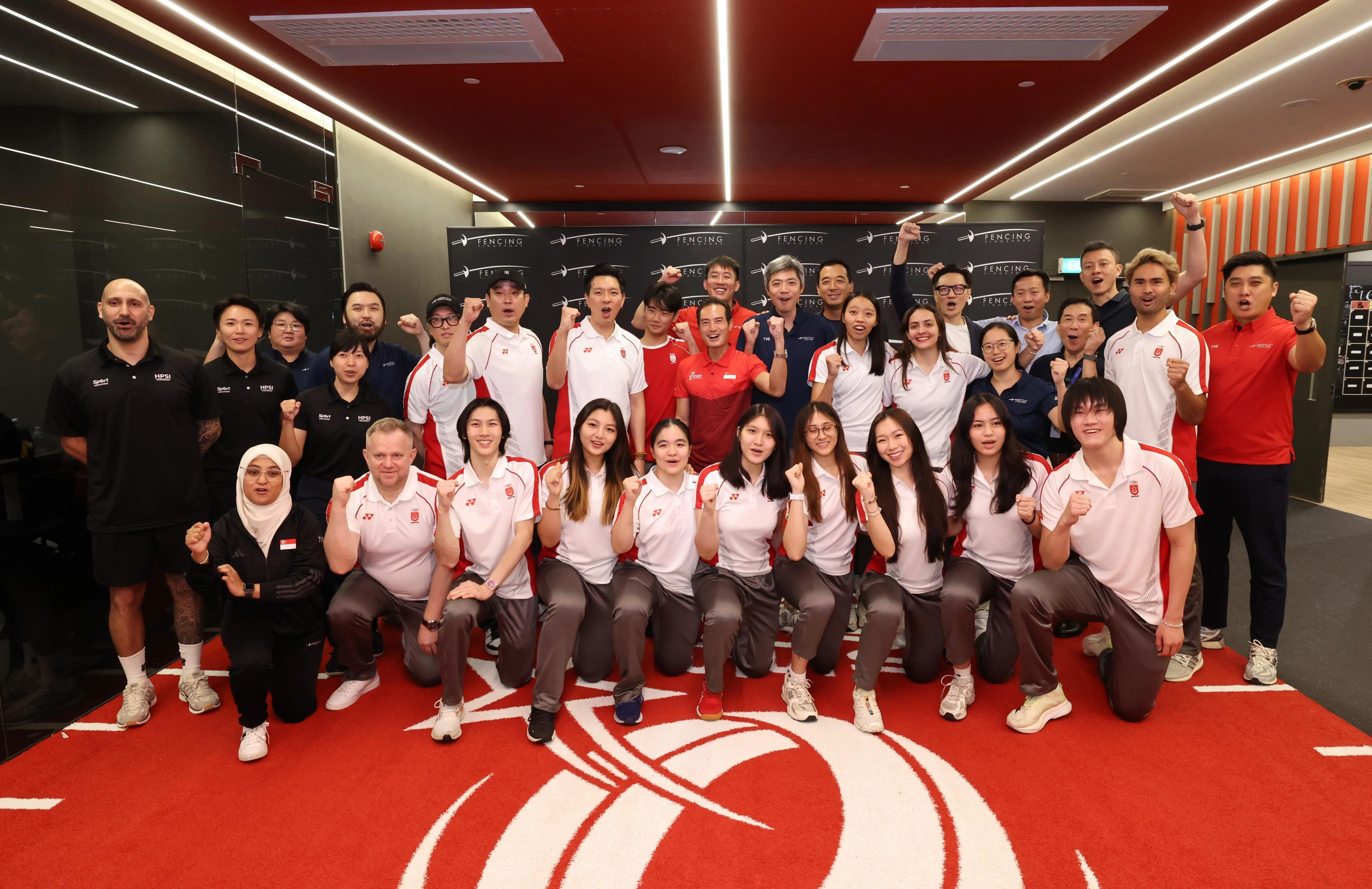 数码发展及新闻部兼卫生部高级政务部长陈杰豪（第二排中红衣）和新加坡击剑队在高水平体育学院（HPSI）健身房合影留念。（梁麒麟摄）