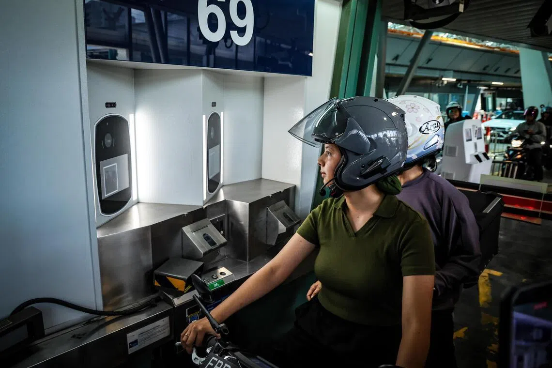 电单车骑士和后座乘客从扫描QR码到完成脸部识别通关，整个过程不超过30秒。（梁麒麟摄）