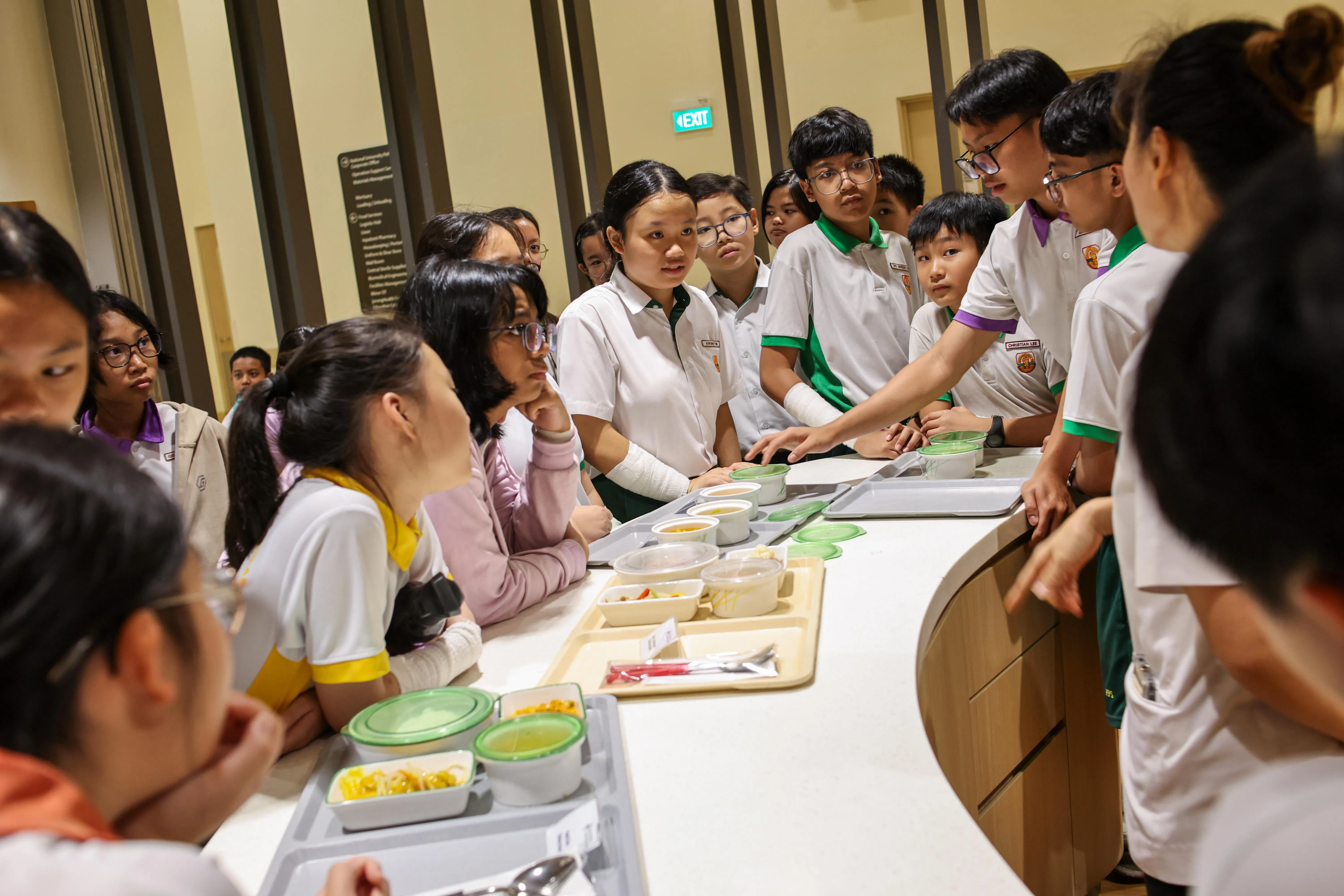 “少年医疗探索家”在医院的中央厨房好奇地研究厨师如何根据每个病患的不同需求量身准备膳食。（陈渊庄摄）