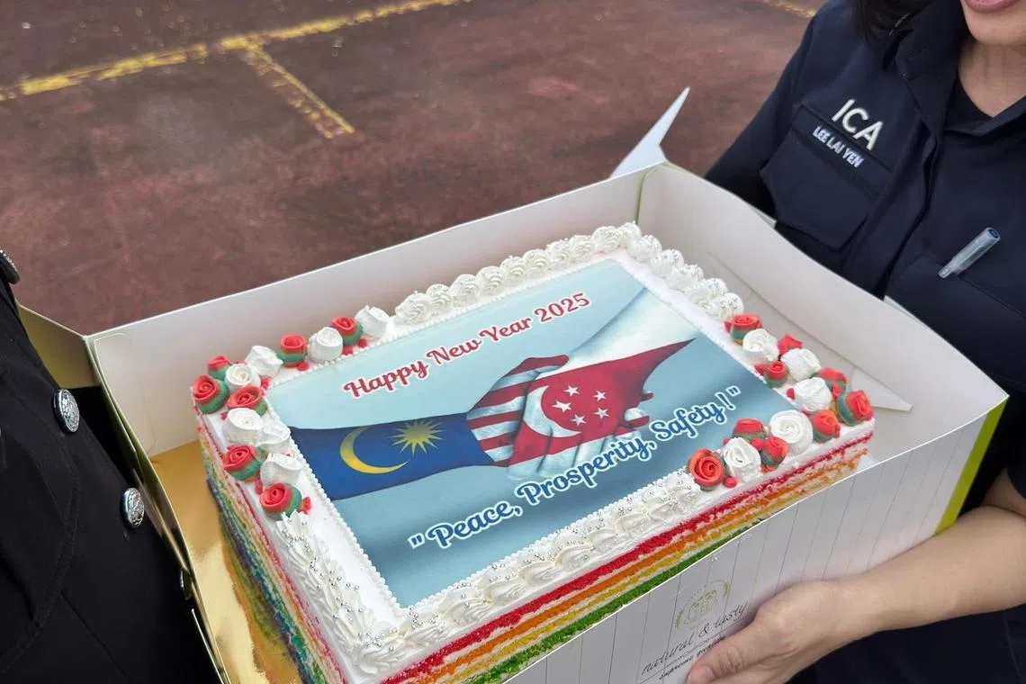 新山关卡官员给兀兰关卡送来新年蛋糕，展现新马两国和平共荣的美好愿望。（取自新山关卡官方脸书）