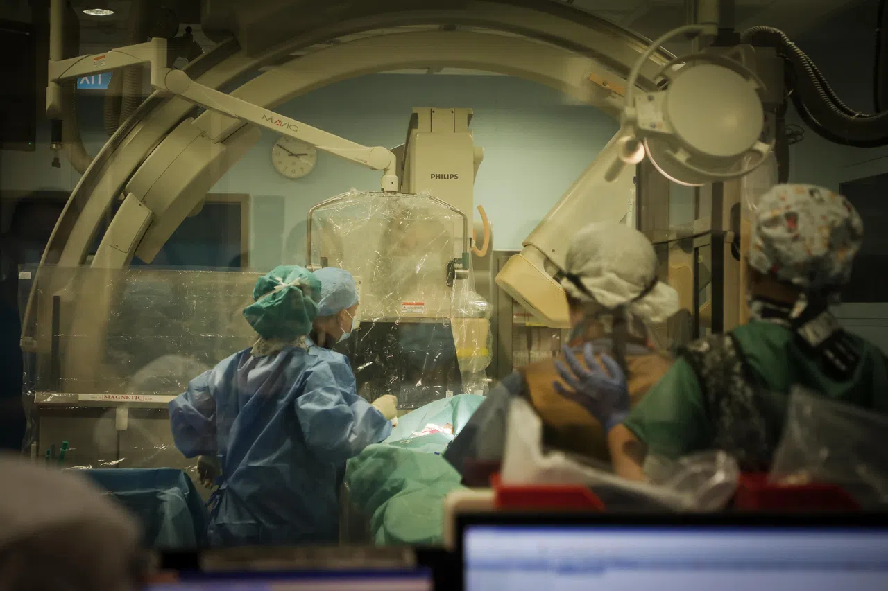 心导管程序通常由一名医生主刀，手术室护士（Scrub Nurse）和巡回护士（Circulating Nurse）等医护人员在旁协助。图为新加坡国家心脏中心团队进行心导管程序的情况。（张恺恩摄）