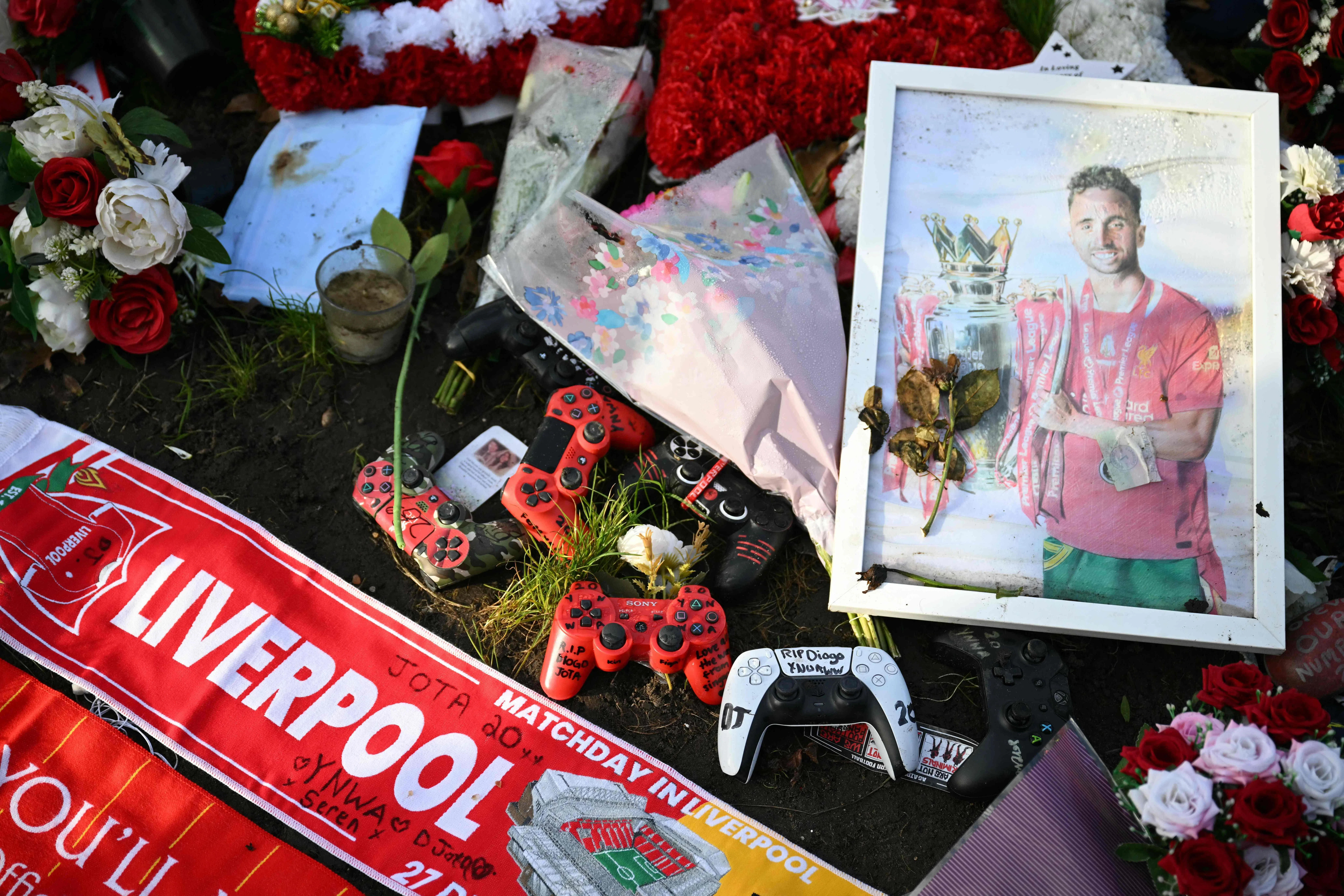 在利物浦上星期六（12月27日）以2比1战胜狼队的比赛前，球迷们自发前往安菲尔德球场附近的纪念处，为生前热爱电竞的若塔送上游戏控制器，并放置他的照片和球队围巾。（法新社）