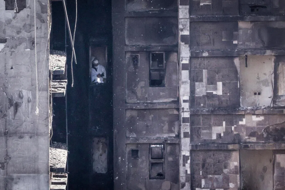 警方星期六动员超过600名“灾难遇害者辨认组”人员，进入两座较迟起火、较早熄灭火种的大厦进行搜索，期间没有发现任何遗骸。图为一名工作人员正在进行搜索作业。（路透社）