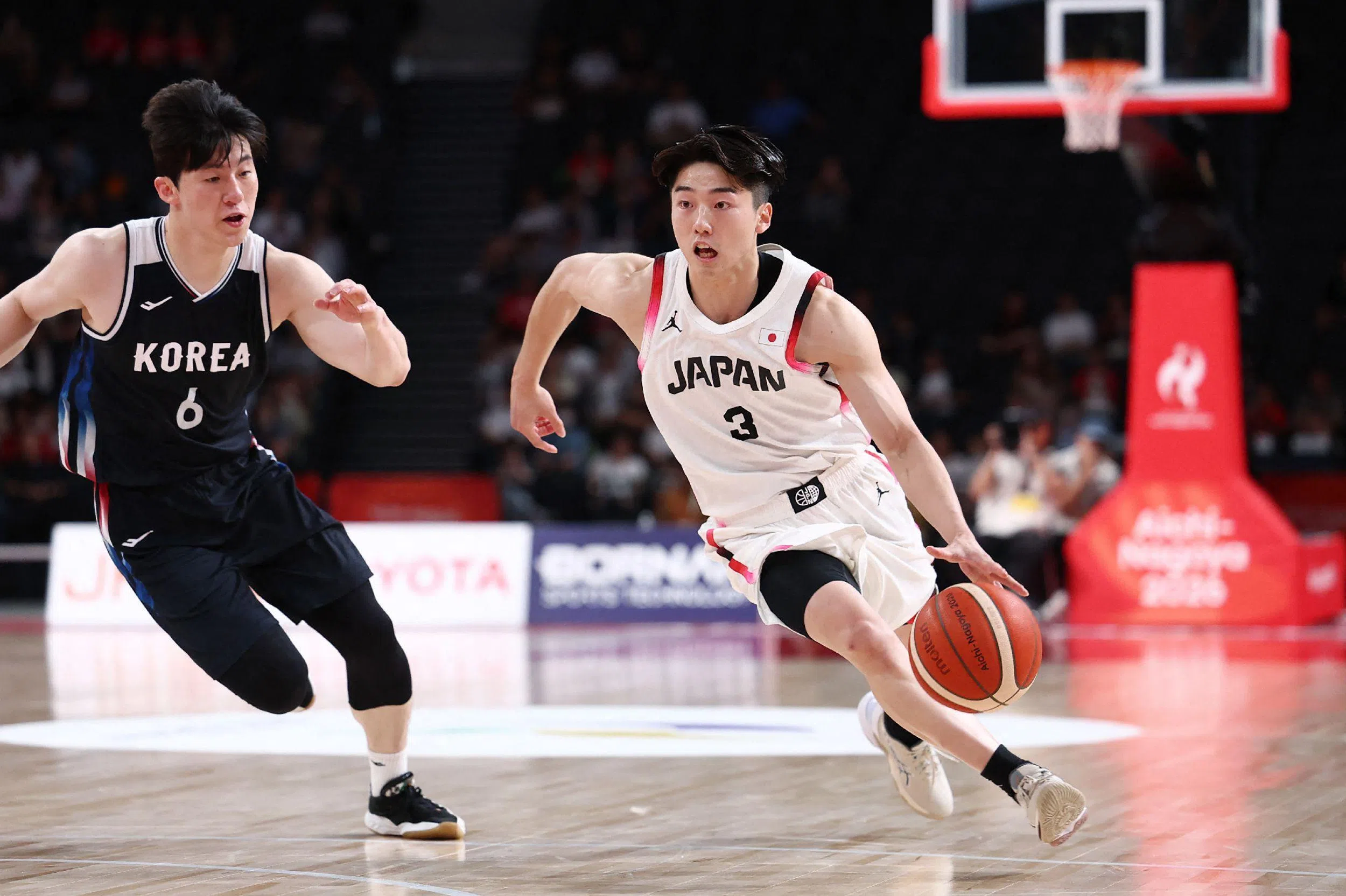 韩国后场核心李政炫（左）本场砍下25分，包括五个三分球，成为球队功臣。图为他在日本球员黑川虎徹带球试图突破时进行防守。（法新社）