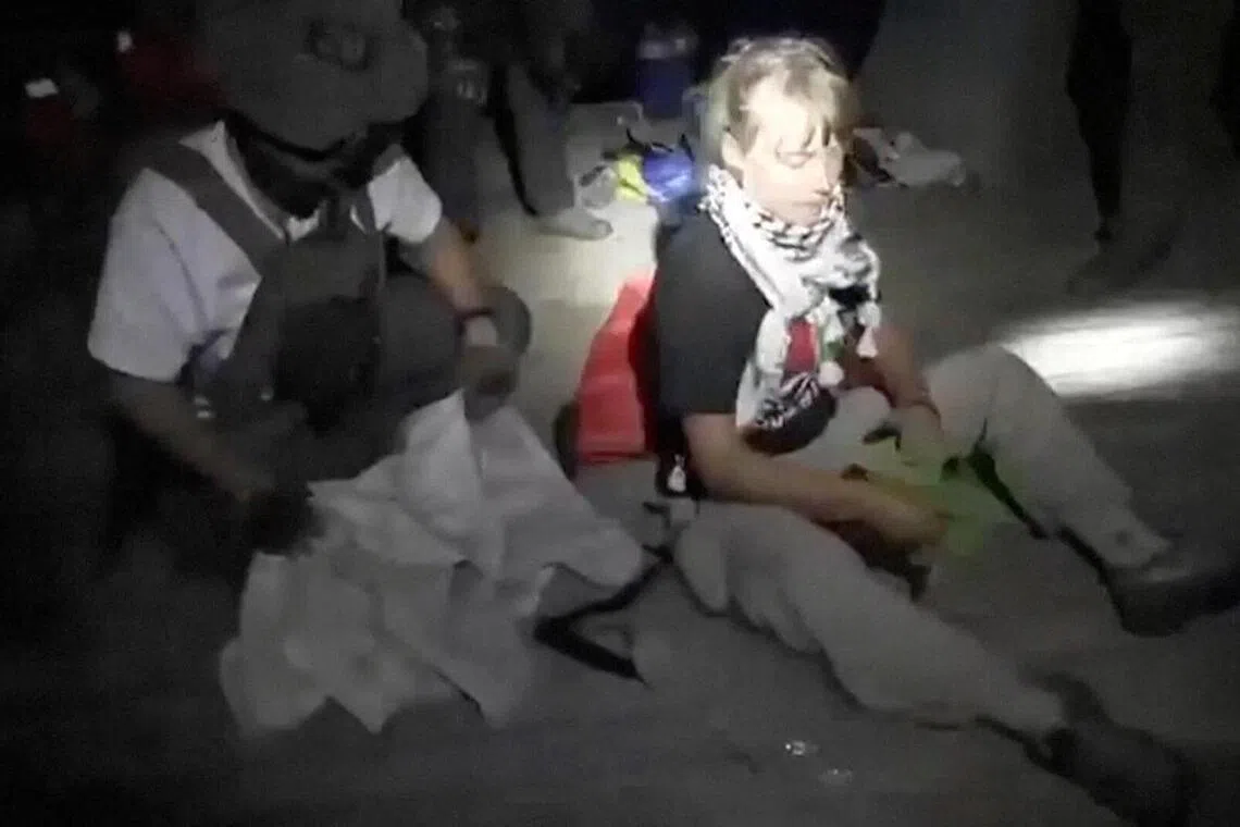 以色列外交部星期三发布的视频截图显示，今年22岁的瑞典青年活动家通贝里（右）坐在一名身穿战术装备的人旁边。（路透社）