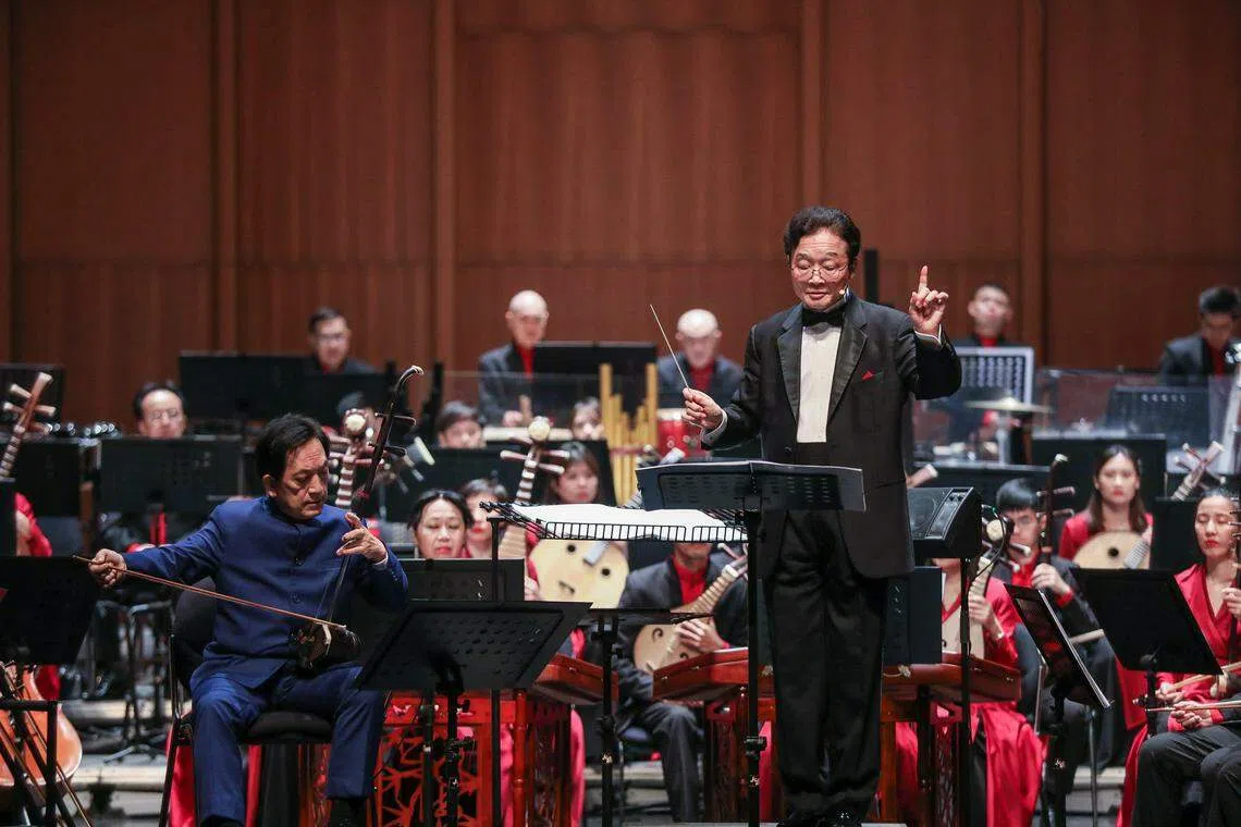 李宝顺（左）担任胡琴协奏曲《火祭》独奏，叶聪转身面向围绕观众席的演奏家，并口念“咒语”，宛如一名远古祭司。（新加坡华乐团提供）