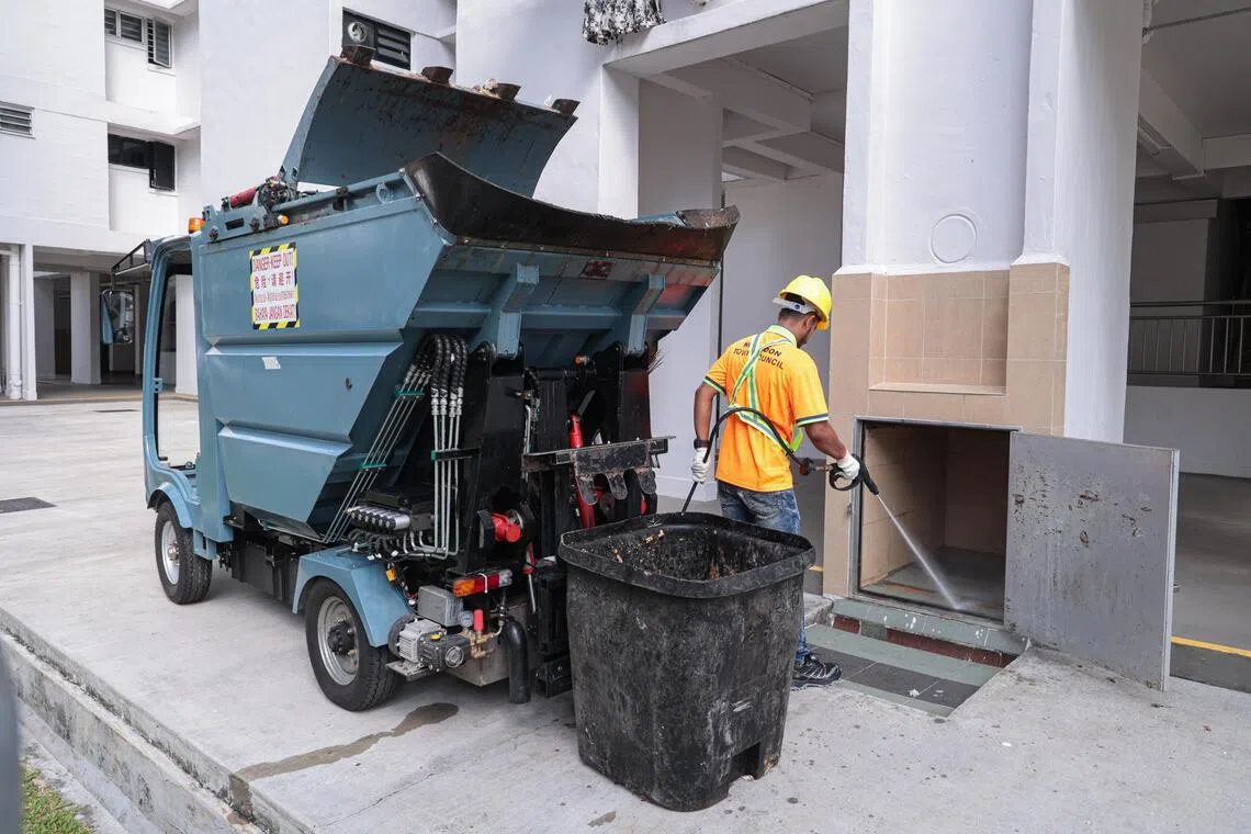 新款垃圾车的高压水枪可直接冲洗垃圾槽、垃圾桶和溢出的残渣，清洁工操作方便又省力。（李冠卫摄）
