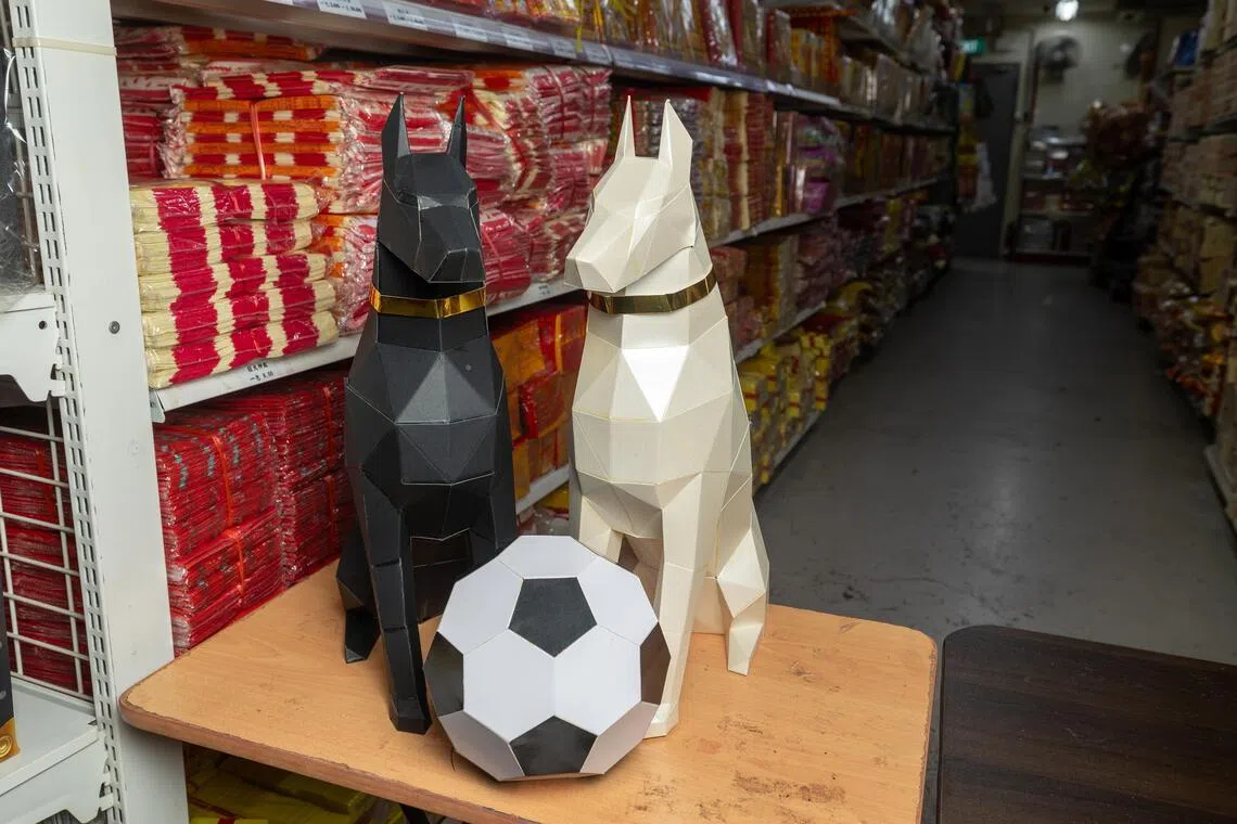 饲养宠物的人越来越多，业者也推出宠物造型纸扎让往生者在另一个世界也能有宠物陪伴。今年的清明节恰逢世界杯临近掀热潮，也推出足球主题祭品。（吴先邦摄）