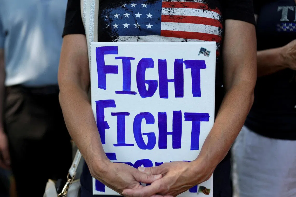 特朗普在巴特勒县竞选集会上被子弹射伤右耳。他在保镖护送下离场时，挥拳高呼“战斗、战斗、战斗”，这成为支持者广泛呼应的口号。（路透社）