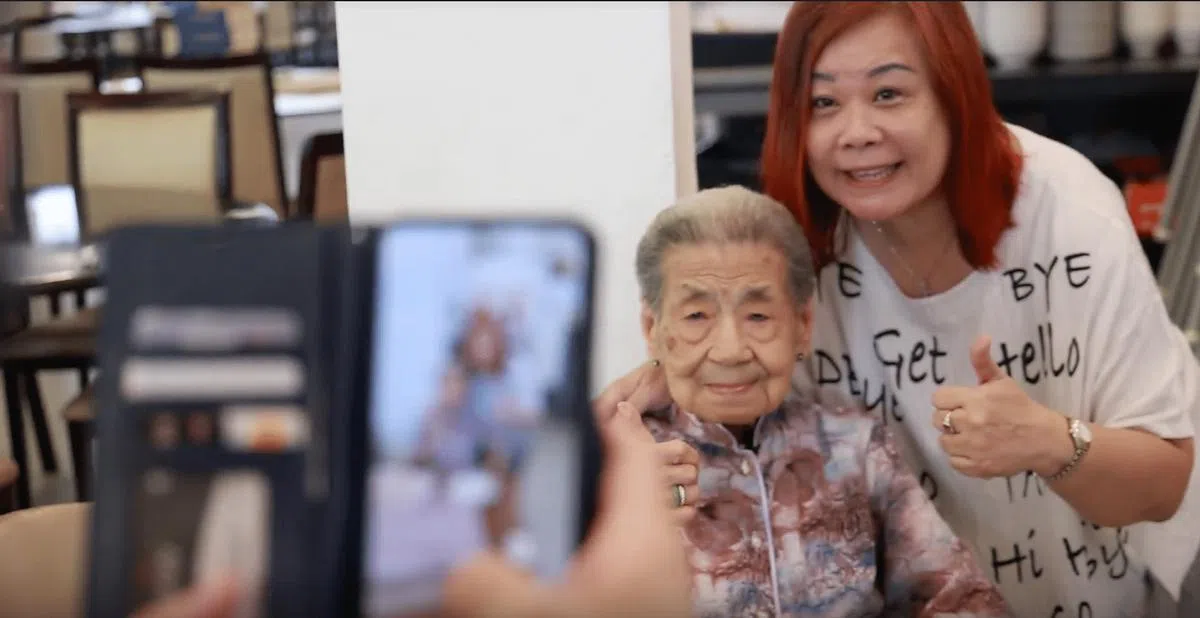 梁月明重出江湖后，不少慕名者去她档口与她合照。