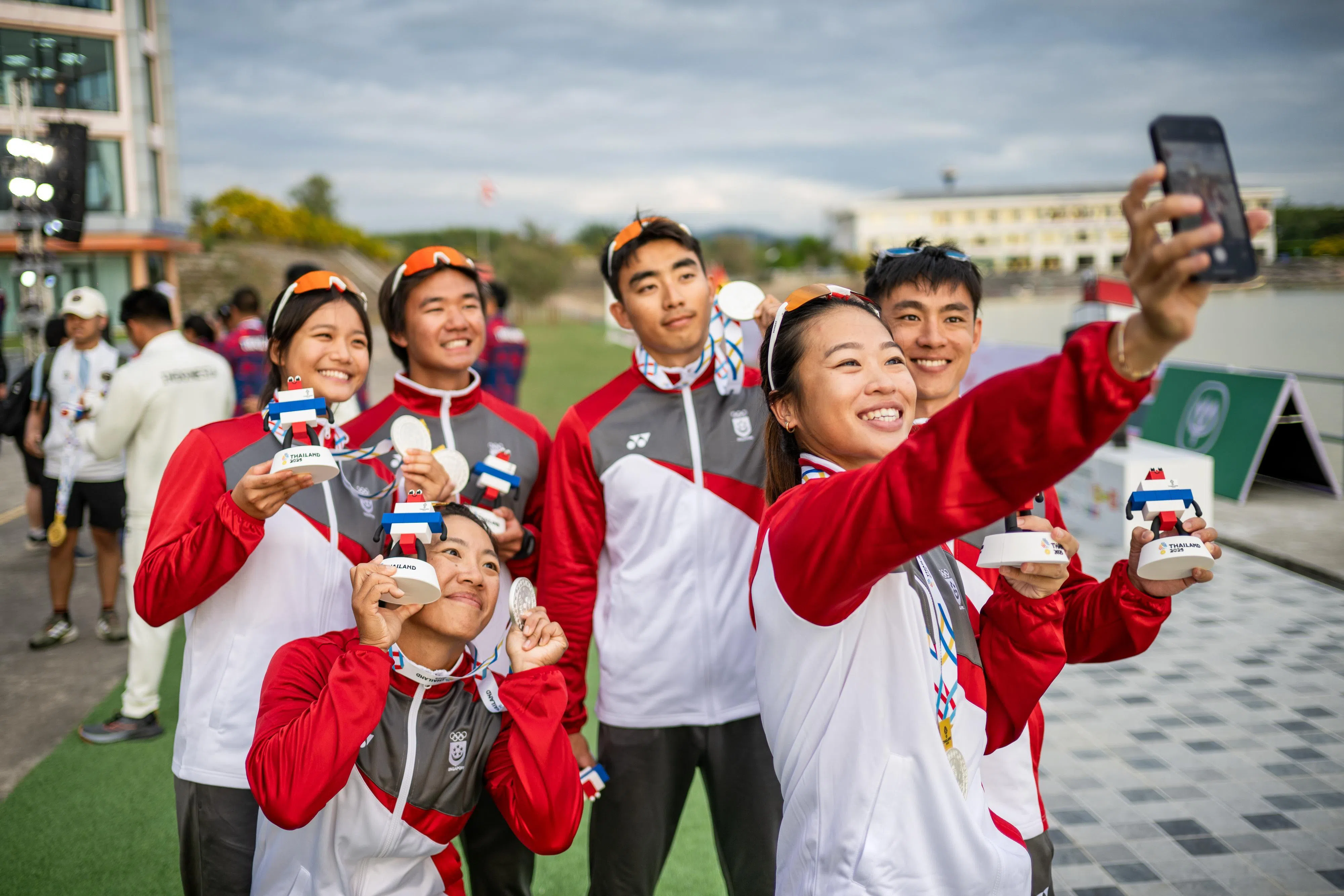 为我国夺得男女四人500米皮艇银牌的六名成员：（后排左起）替补戴凯乐和曾宪安、吕俊辉、黄伟成、陈洁娴（蹲者）和黄倪轩（握手机者），在颁奖仪式结束后自拍留念。（体理会提供）