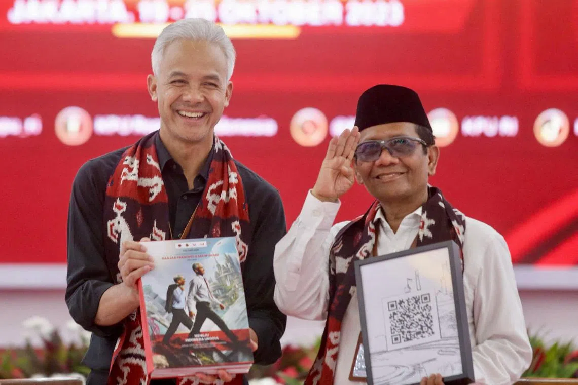 印尼执政党斗争派民主党的总统候选人甘查尔（左）与竞选搭档马福德在候选人登记首日，顺利完成登记参选的程序。（法新社）