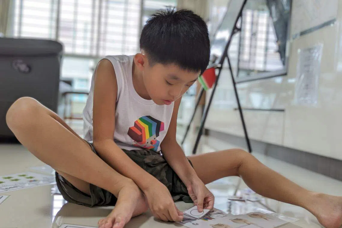 哥哥蔡玮桓喜欢静静地坐在一旁，玩妈妈为他和弟弟制作的学习教材。（杨雯婷摄）