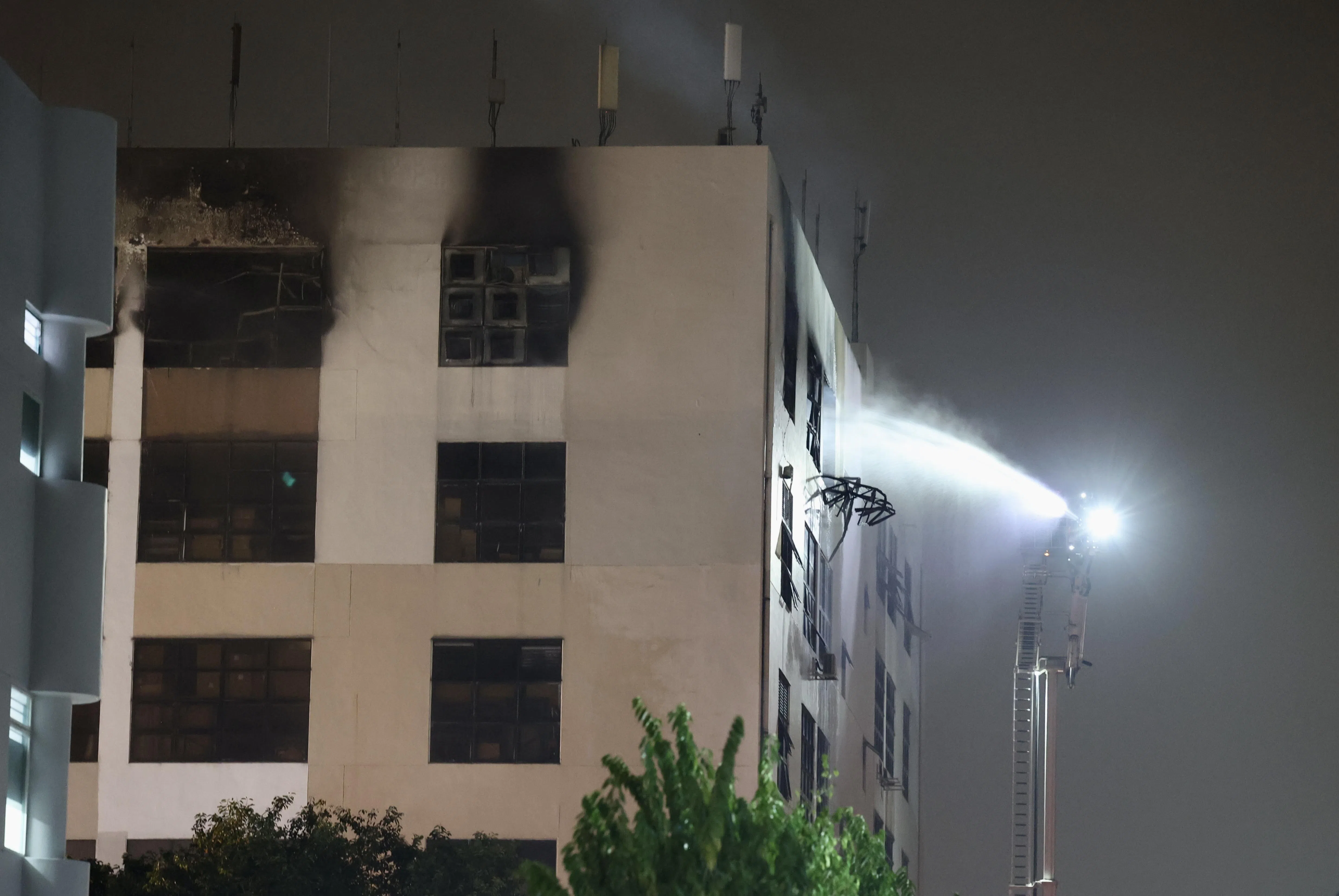 消防员出动一架云梯消防车，从建筑外围灭火。（邬福梁摄）