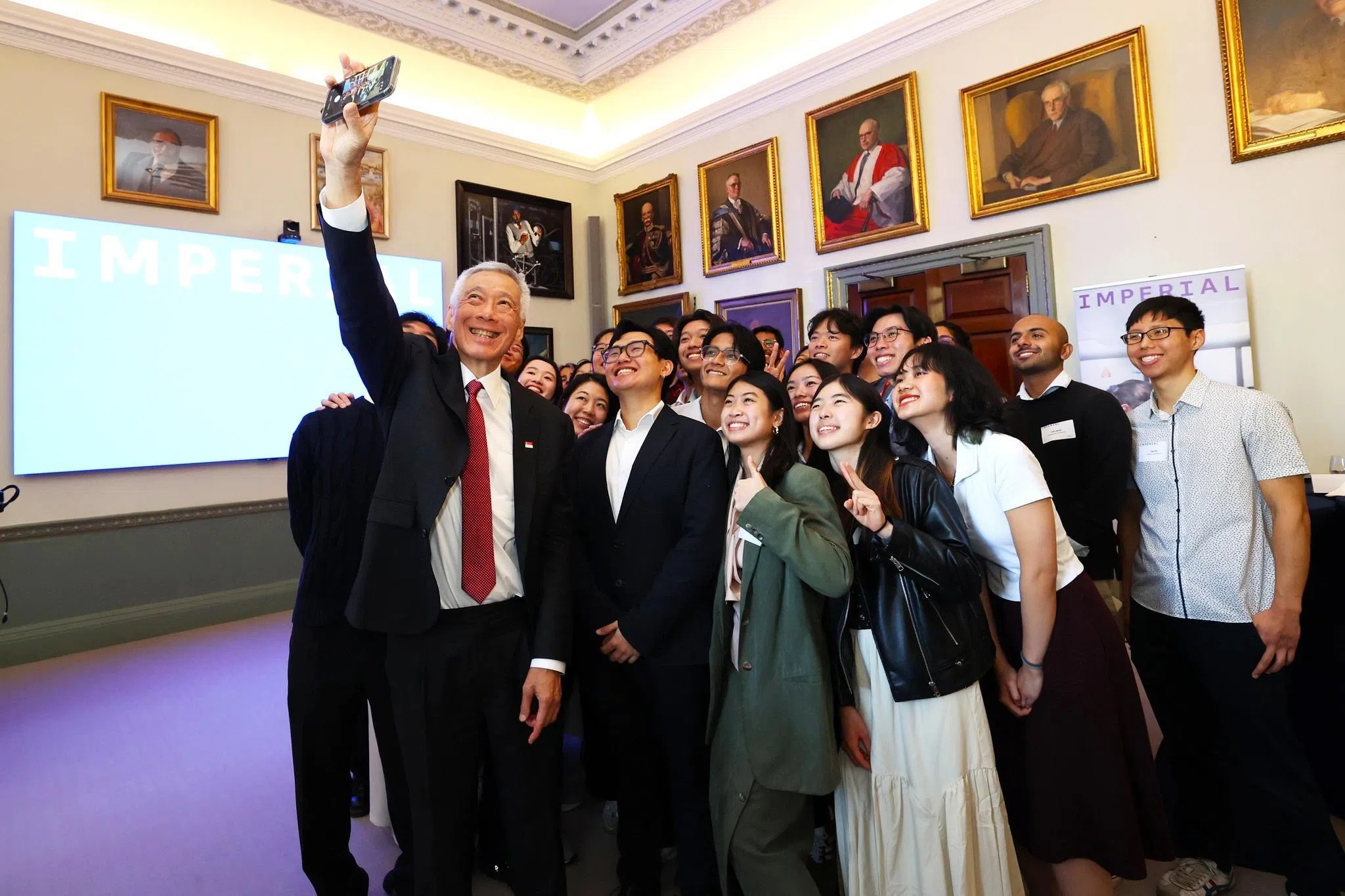 国务资政李显龙（前排左一）星期二与一群在伦敦帝国理工学院求学的新加坡留学生自拍合照。他说：“他们有的刚刚开始本科学习，有的已经读到最后一年了，还有一些是研究生。无论你处在哪个阶段，我都希望你们继续追寻自己的热情，为世界带来积极的影响！”（数码发展及新闻部提供）