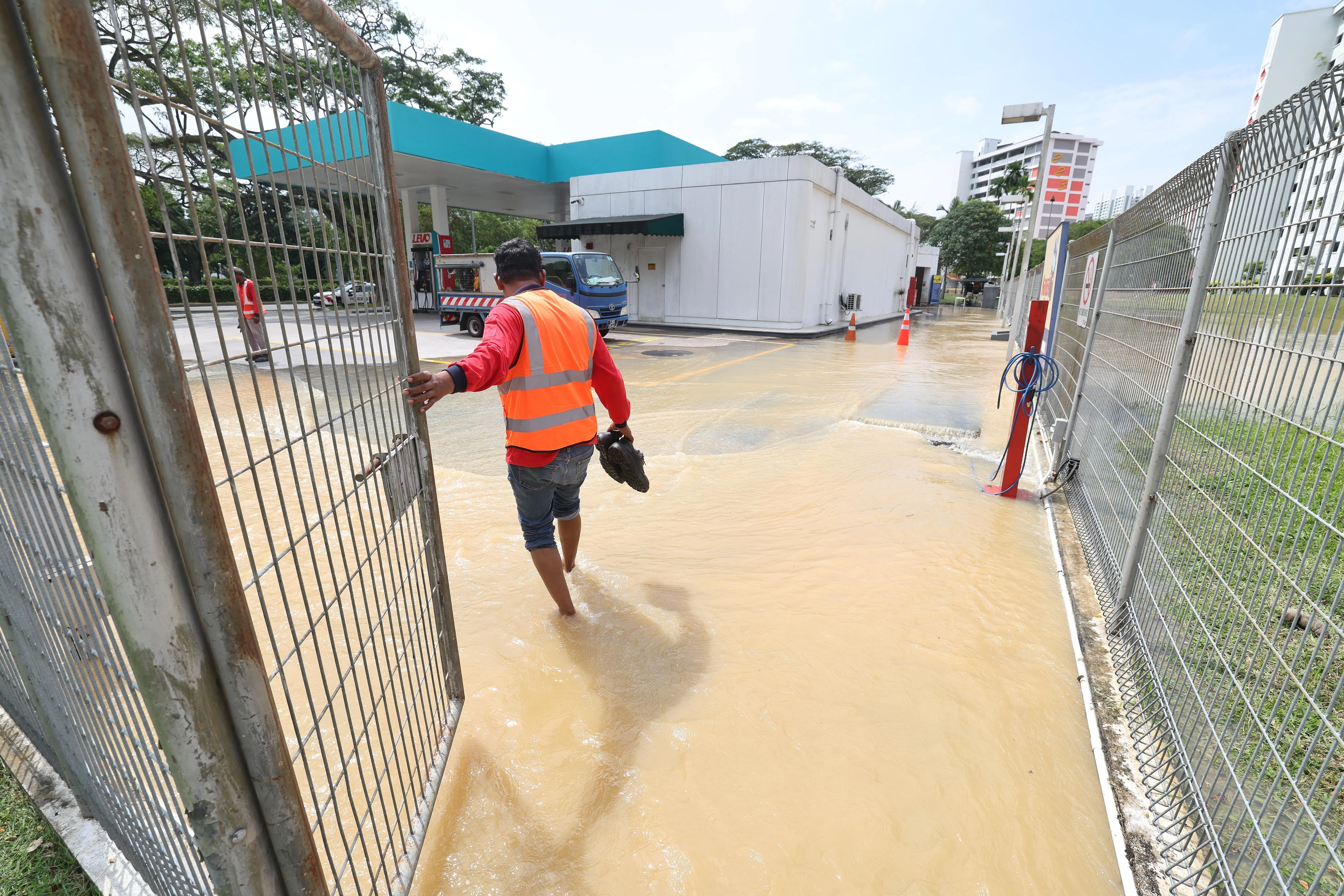 积水导致车子无法驶入油站后方，油站被迫从中午12时左右暂停洗车服务。（唐家鸿摄）