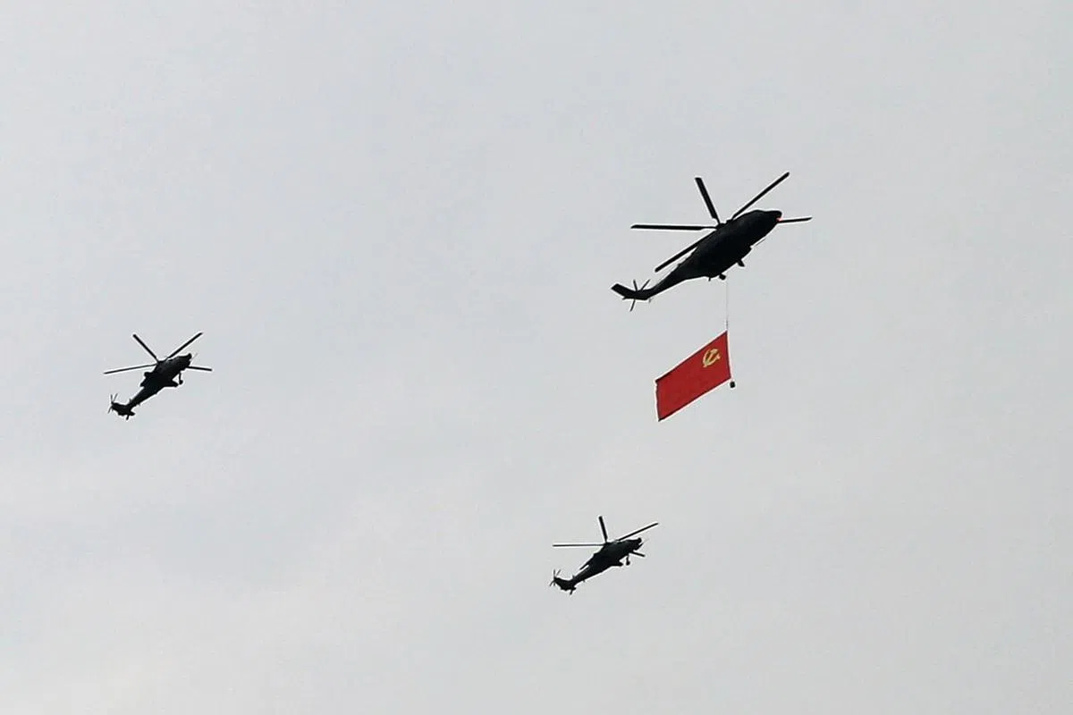 解放军军机举着中共党庆，飞过天安门广场上空。（路透社）