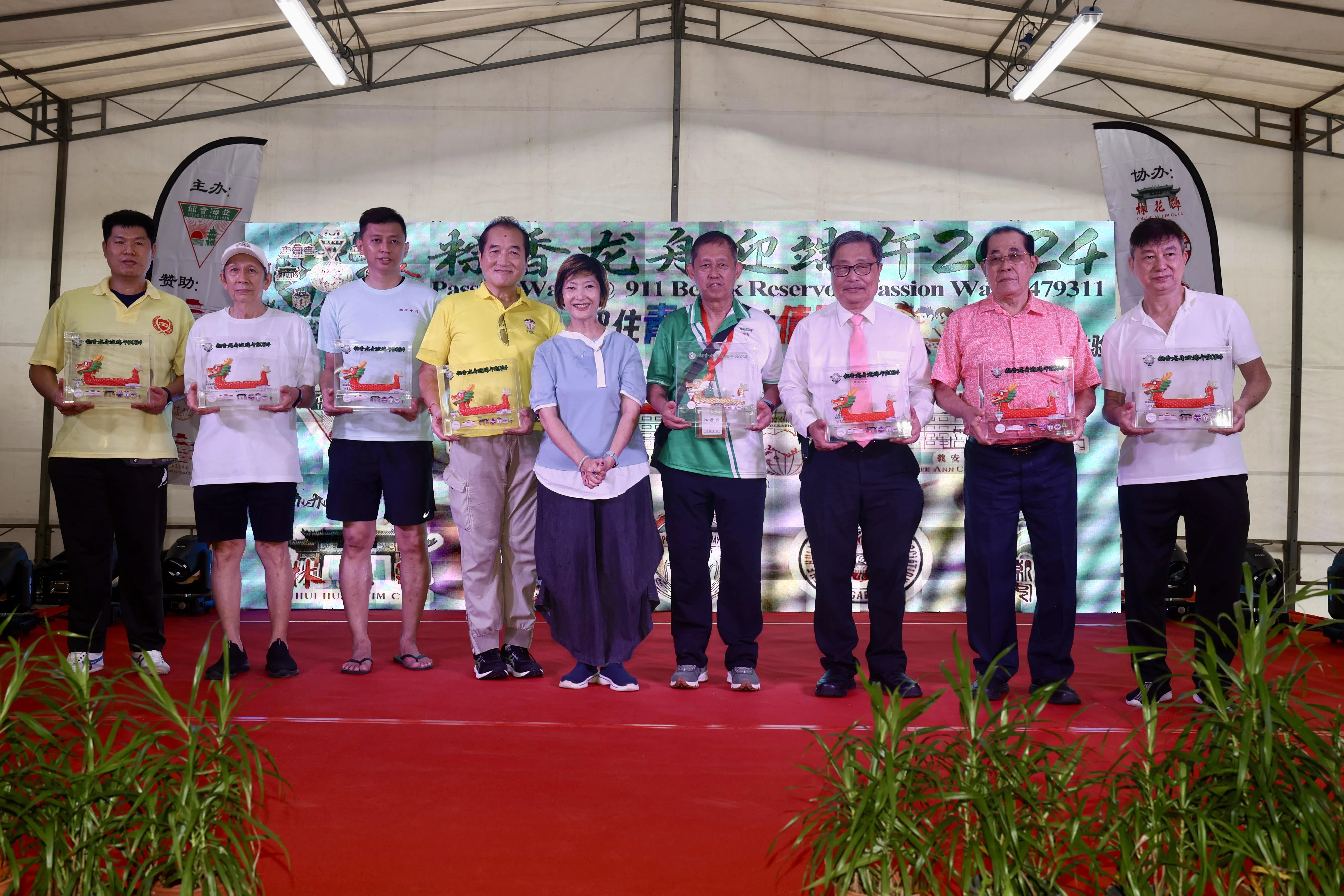 澄海会馆准备了精美的龙舟造型纪念品送给参与的潮团，由马炎庆夫人林海燕（中）颁发。（郑一鸣摄）