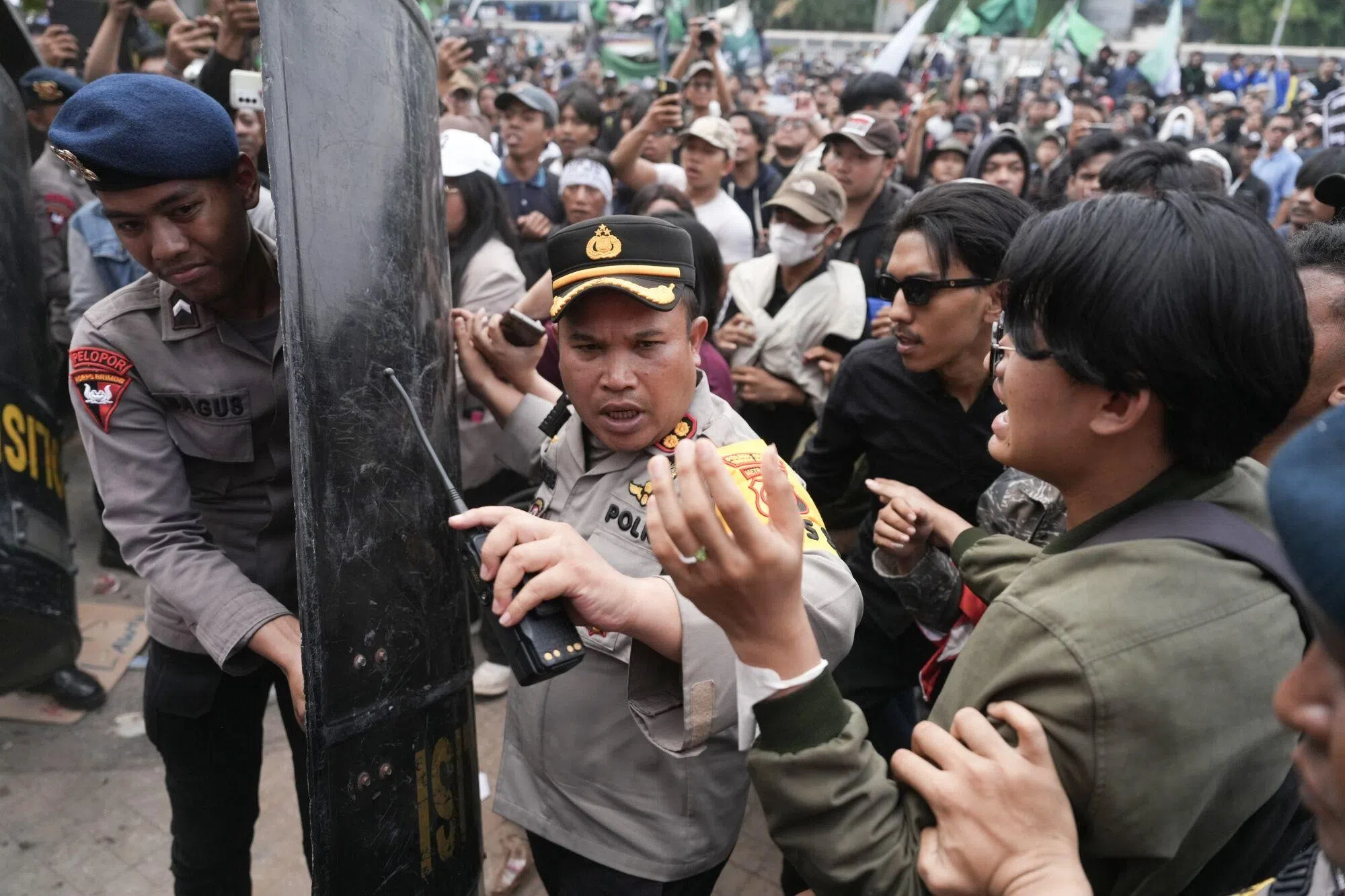 雅加达市政府至少部署了3200名警察，应对可能发生的冲突。图为警察阻挡民众接近议会大厦。（彭博社）