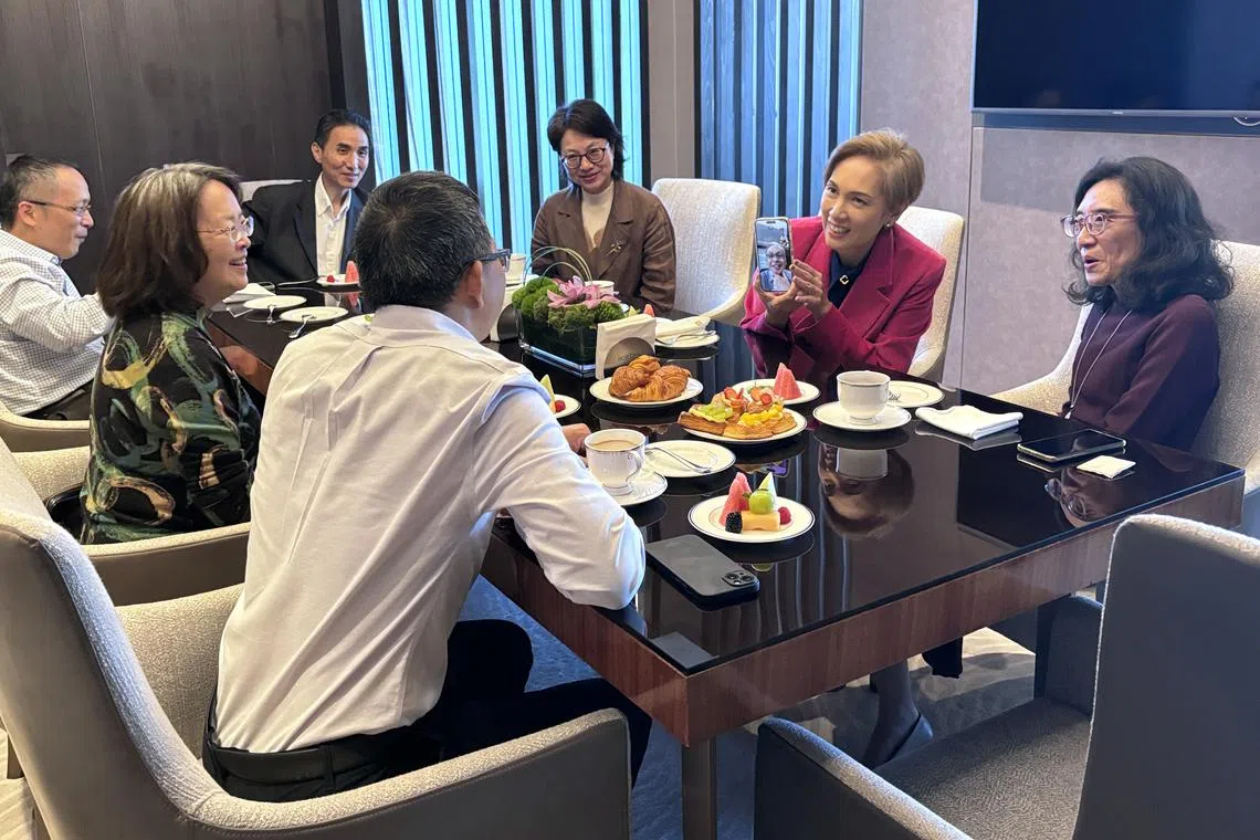 数码发展及新闻部长杨莉明（右二）星期五（10月11日）与苏州老朋友见面叙旧时，通过手机与先生张永昌视频连线，和老朋友逐一通话。张永昌是中新天津生态城投资开发有限公司总裁，他在经济发展局任职时，也曾派驻苏州参与园区项目。（黎康摄）