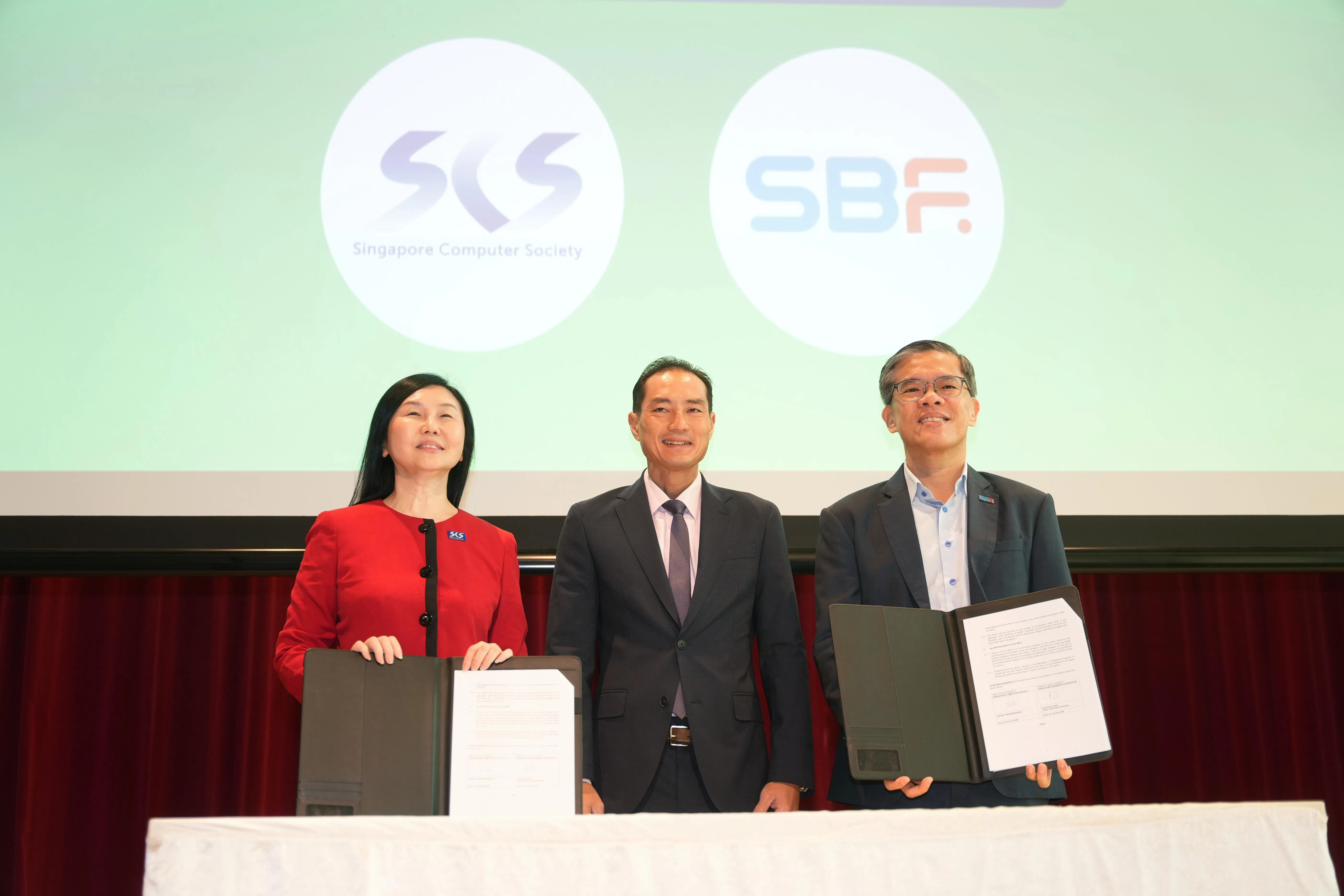 新加坡电脑学会会长林镁绢（左）与新加坡工商联合总会执行总裁郭柄汛（右）代表签署谅解备忘录。数码发展及新闻部兼卫生部高级政务部长陈杰豪（中）在旁见证。（谢智扬摄）