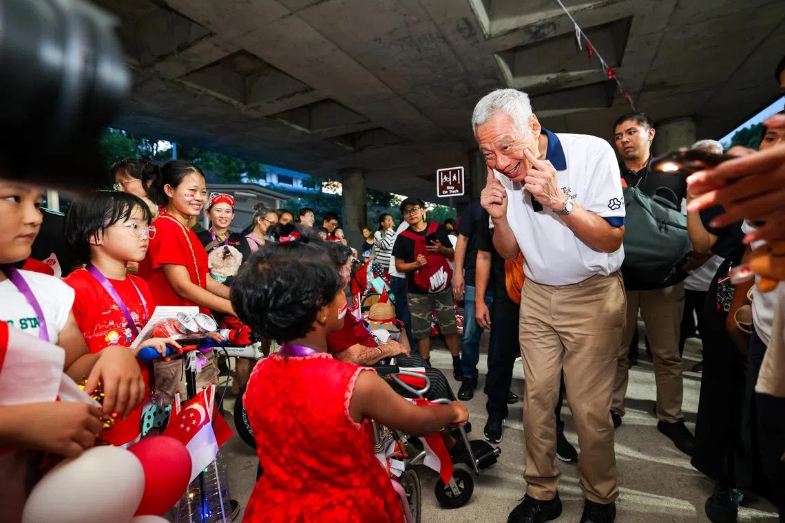 国务资政李显龙（右）星期六出席在地铁高架桥底下举行的德义区SG60嘉年华，与居民亲切交流。（林明顺摄）