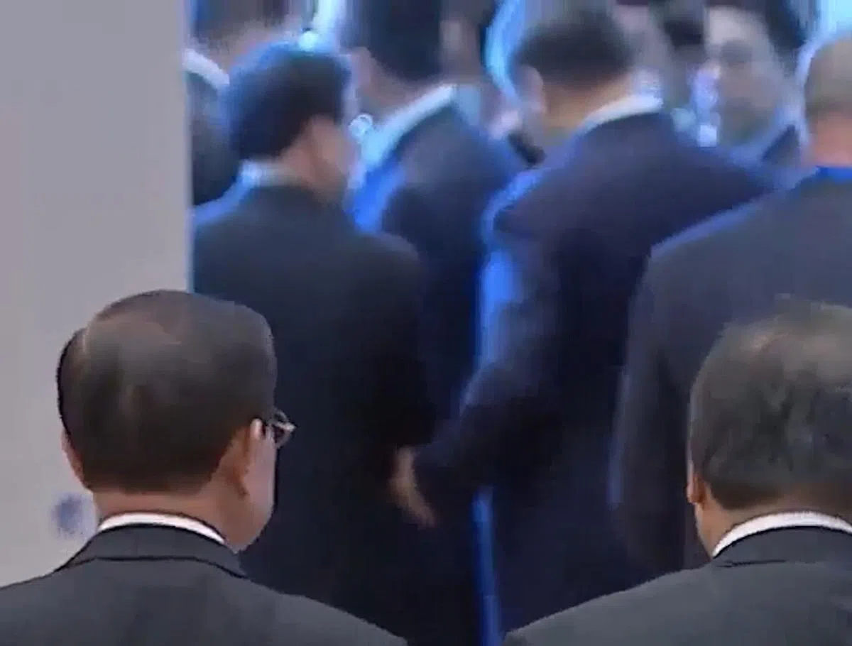 泰国首相巴育欢送各国领袖时，直播画面见到远处，中国国家主席习近平主动挽着香港特首李家超的手臂，一直交谈并行离场。（APEC直播截图）